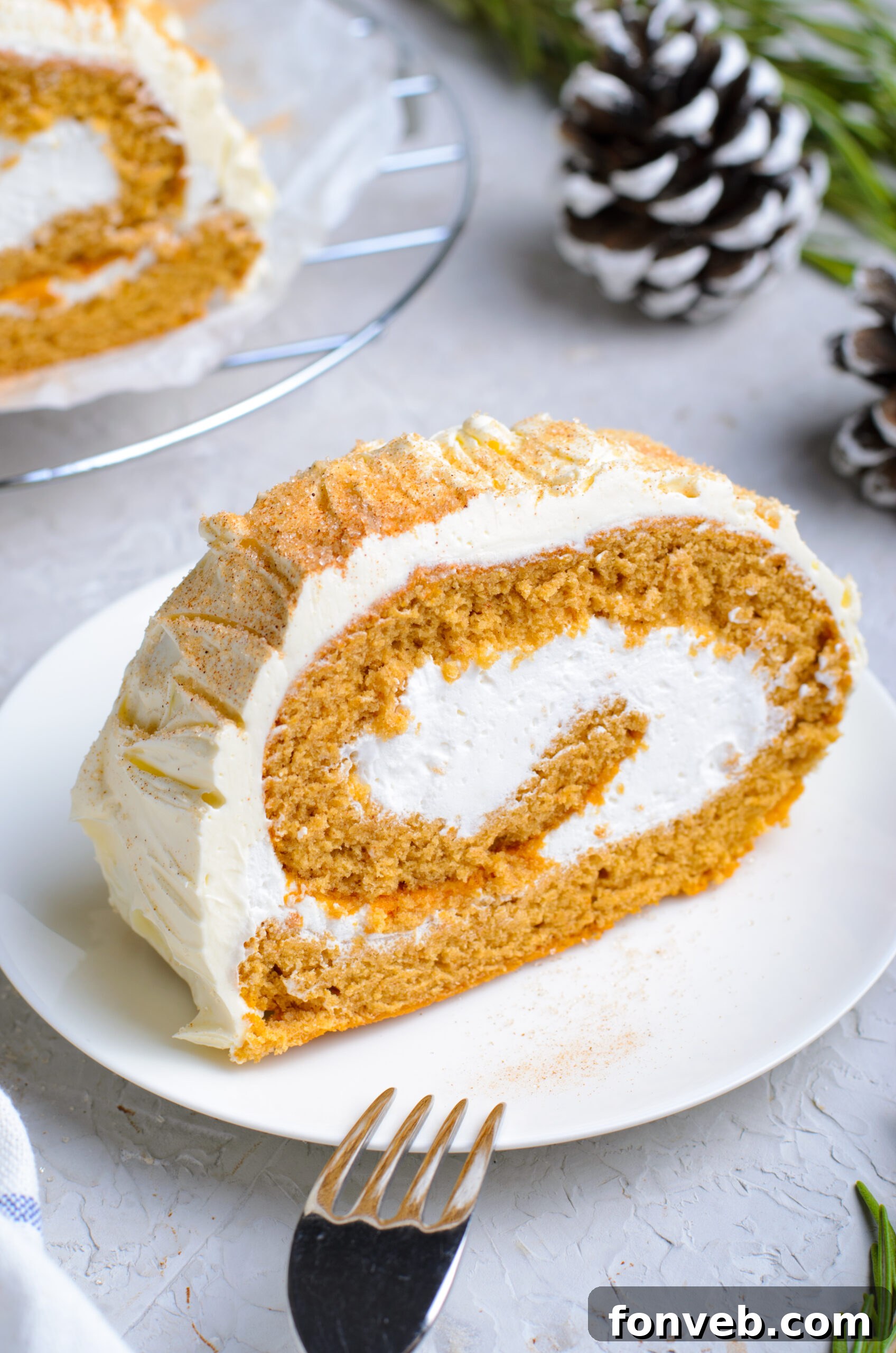 Front view of a slice of GIngerbread Cake Roll on a white plate.