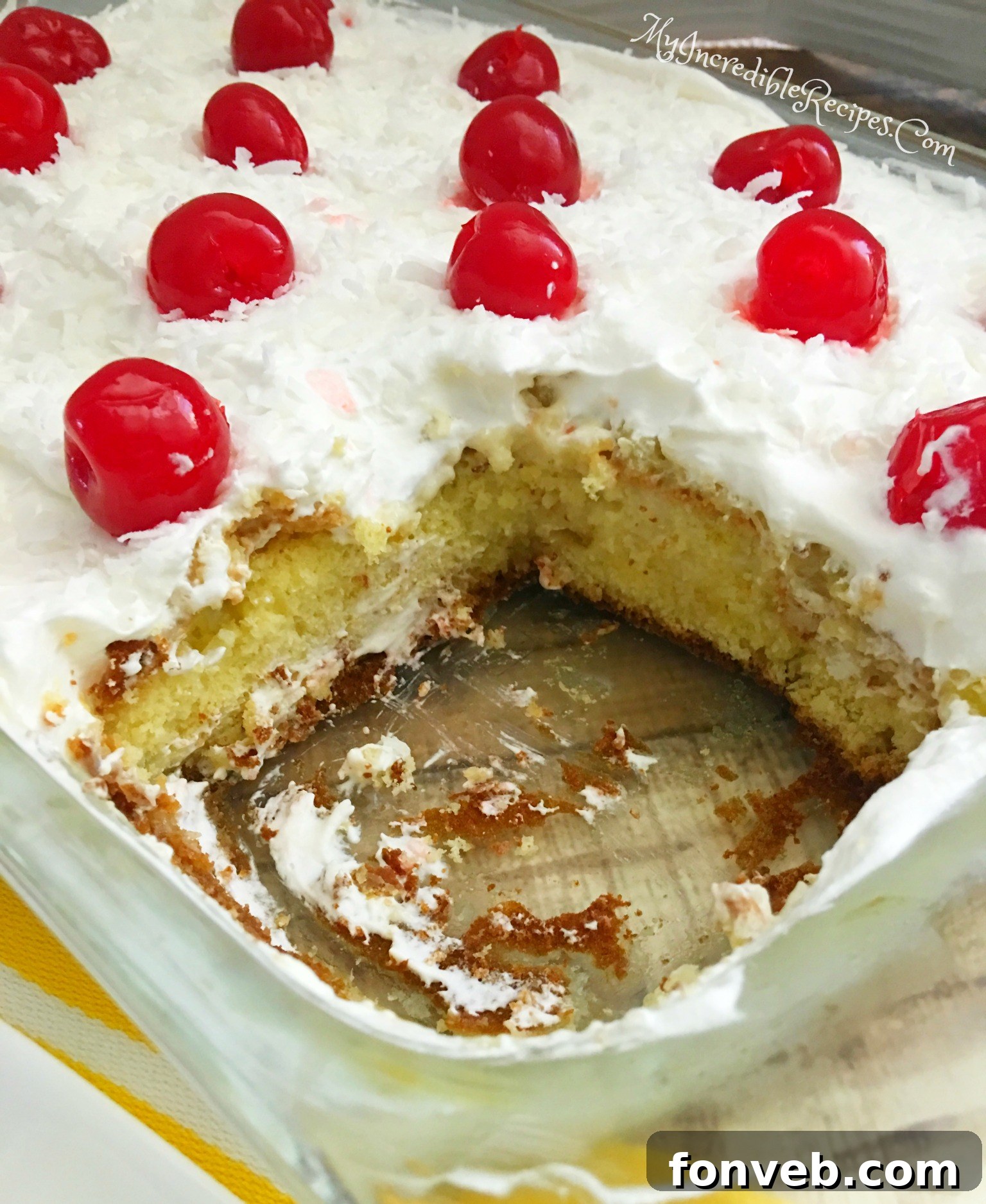 Finished Pina Colada Poke Cake topped with cherries and coconut