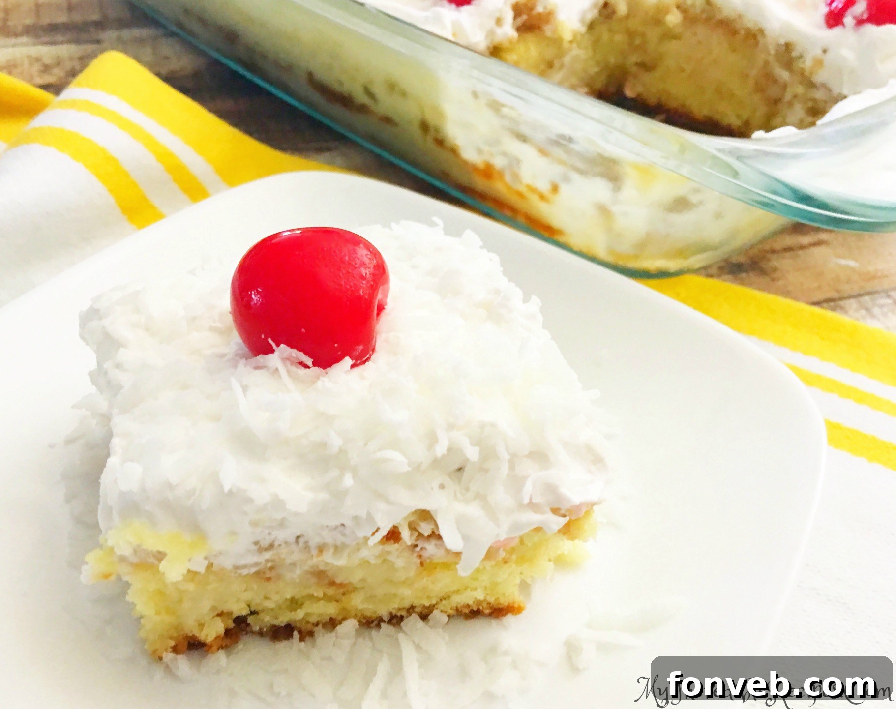 Side view of a slice of Pina Colada Poke Cake with all layers visible