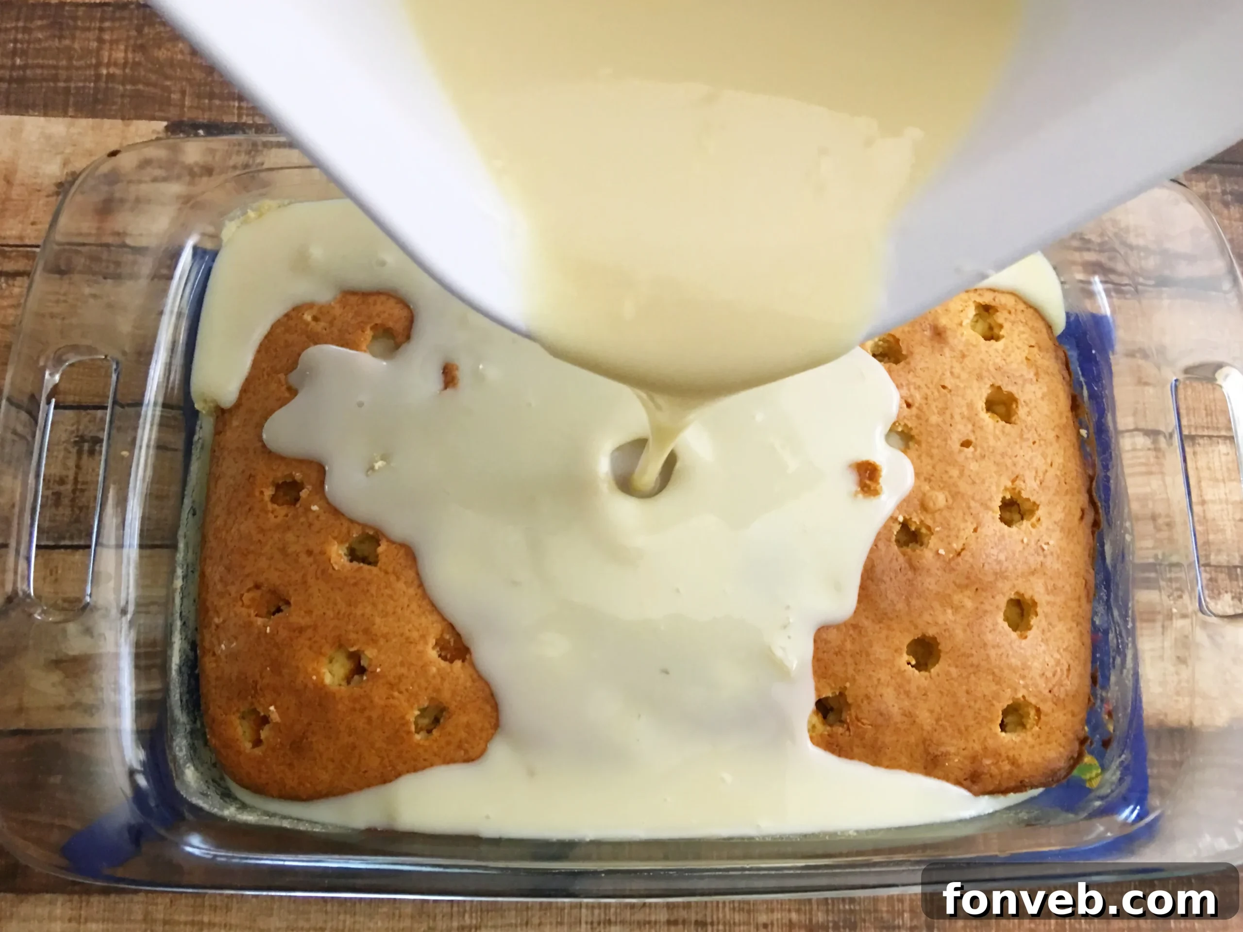 Freshly baked pound cake with holes poked in it, ready for infusion