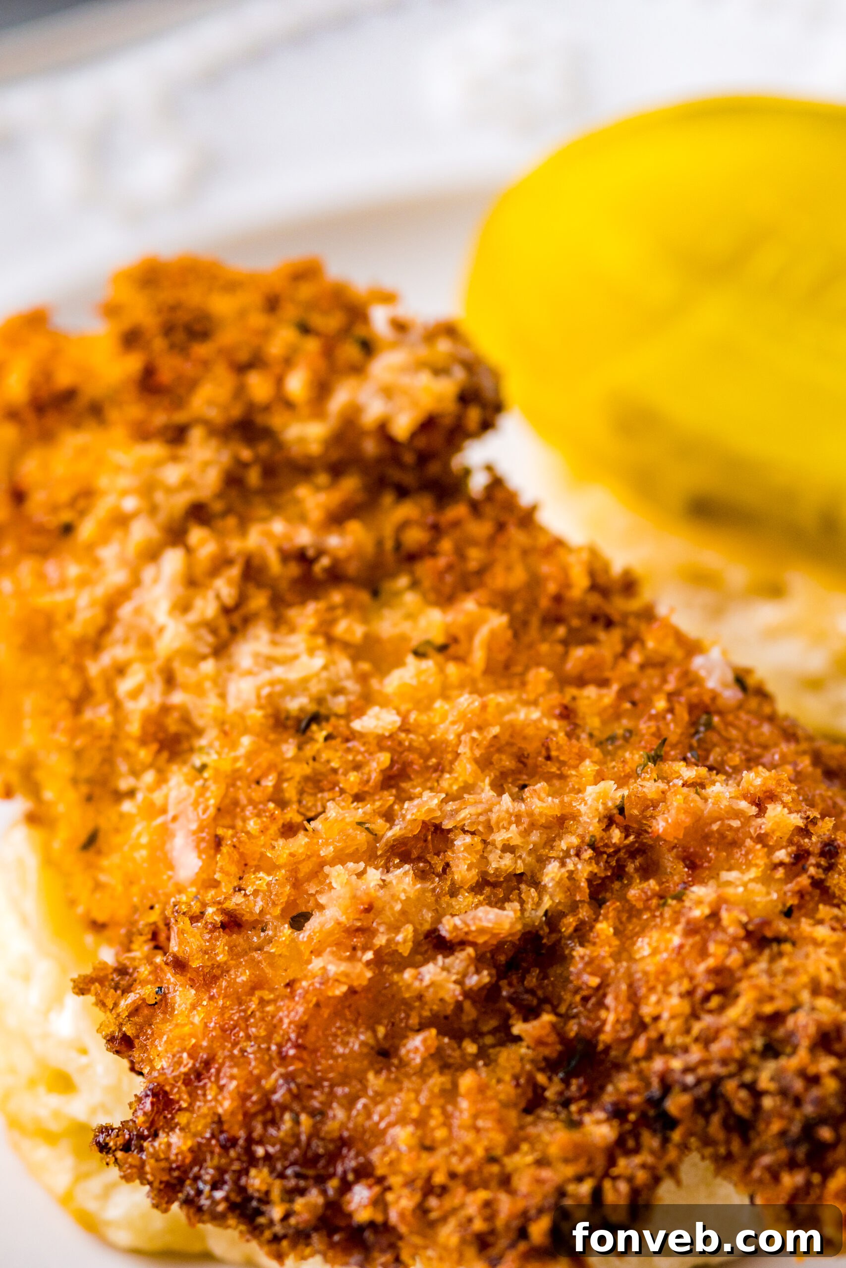 Close up view of a fully assembled Honey Butter Chicken Biscuit, showcasing the crispy chicken texture.
