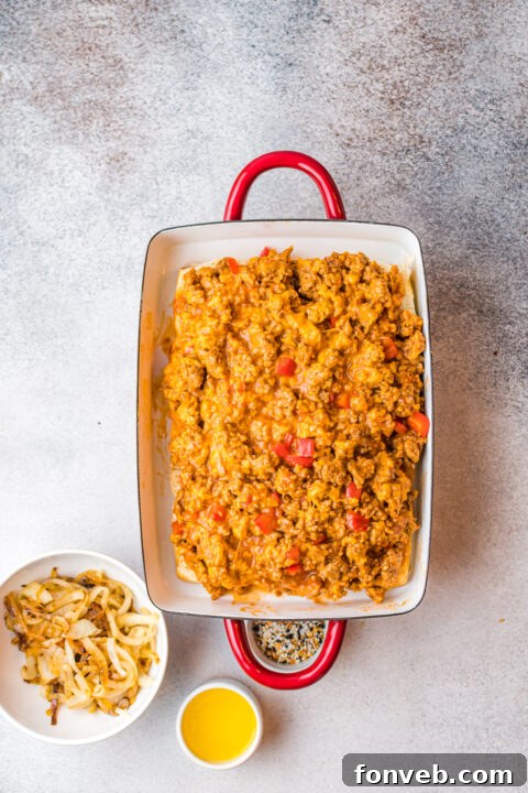 Step-by-step image of adding shredded cheese to the chicken mixture.