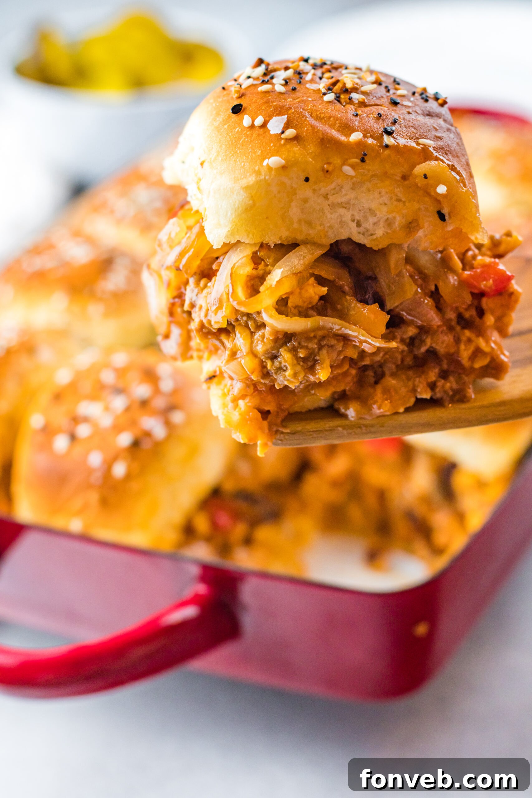 Front view of a Cheesy Chicken Sloppy Joe Slider on a wooden spatula, ready to be enjoyed.