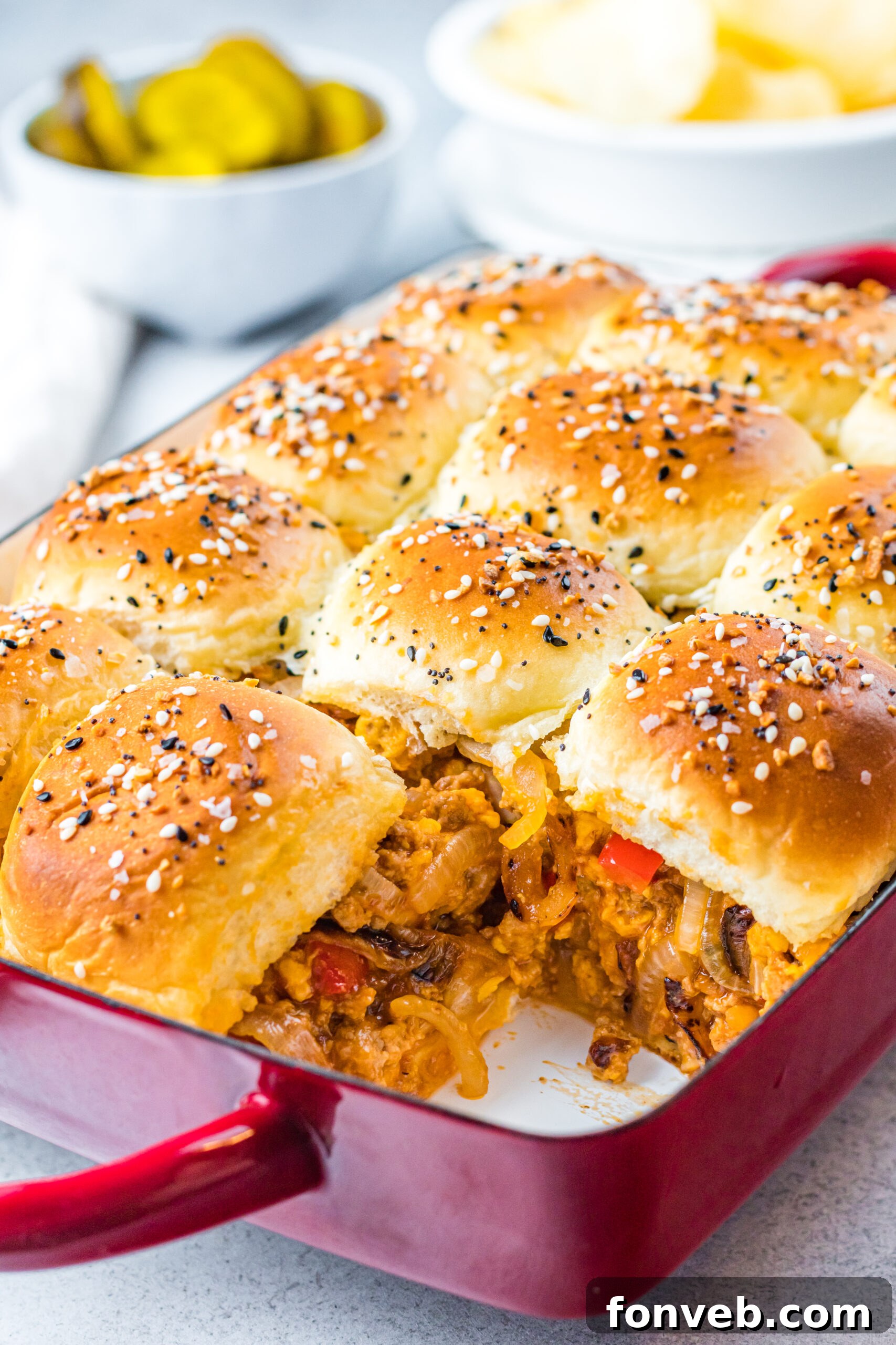 Front view of Cheesy Chicken Sloppy Joe Sliders in a red baking dish, ready to serve.