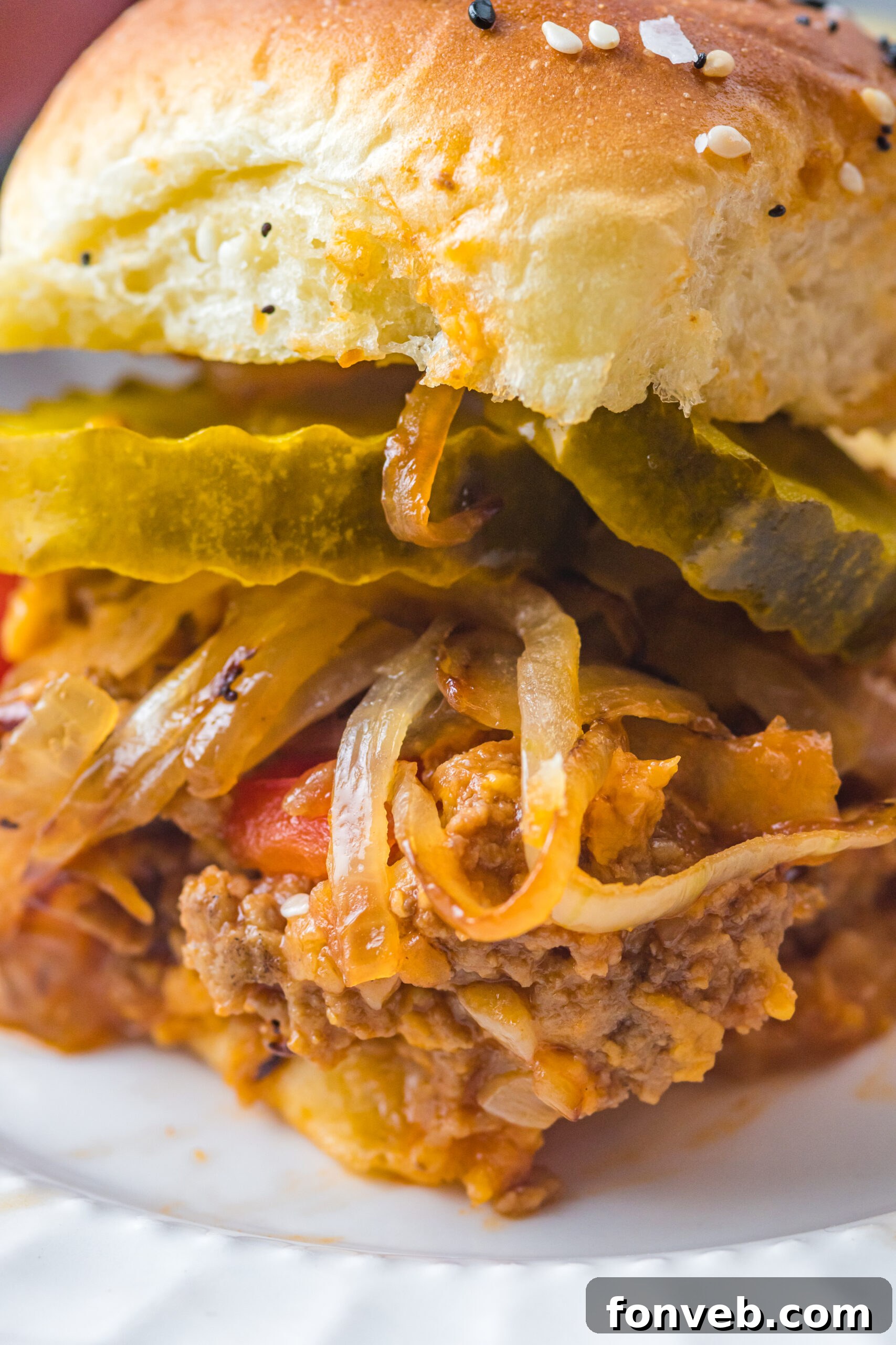 Close up view of a Cheesy Chicken Sloppy Joe Slider, highlighting the melted cheese and juicy filling.