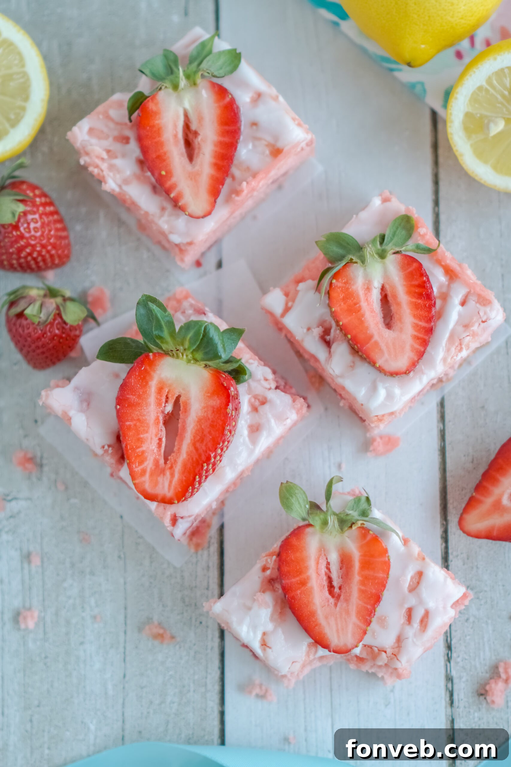 Overhead view of perfectly glazed Strawberry Lemon Brownies on parchment paper, cut into neat squares.