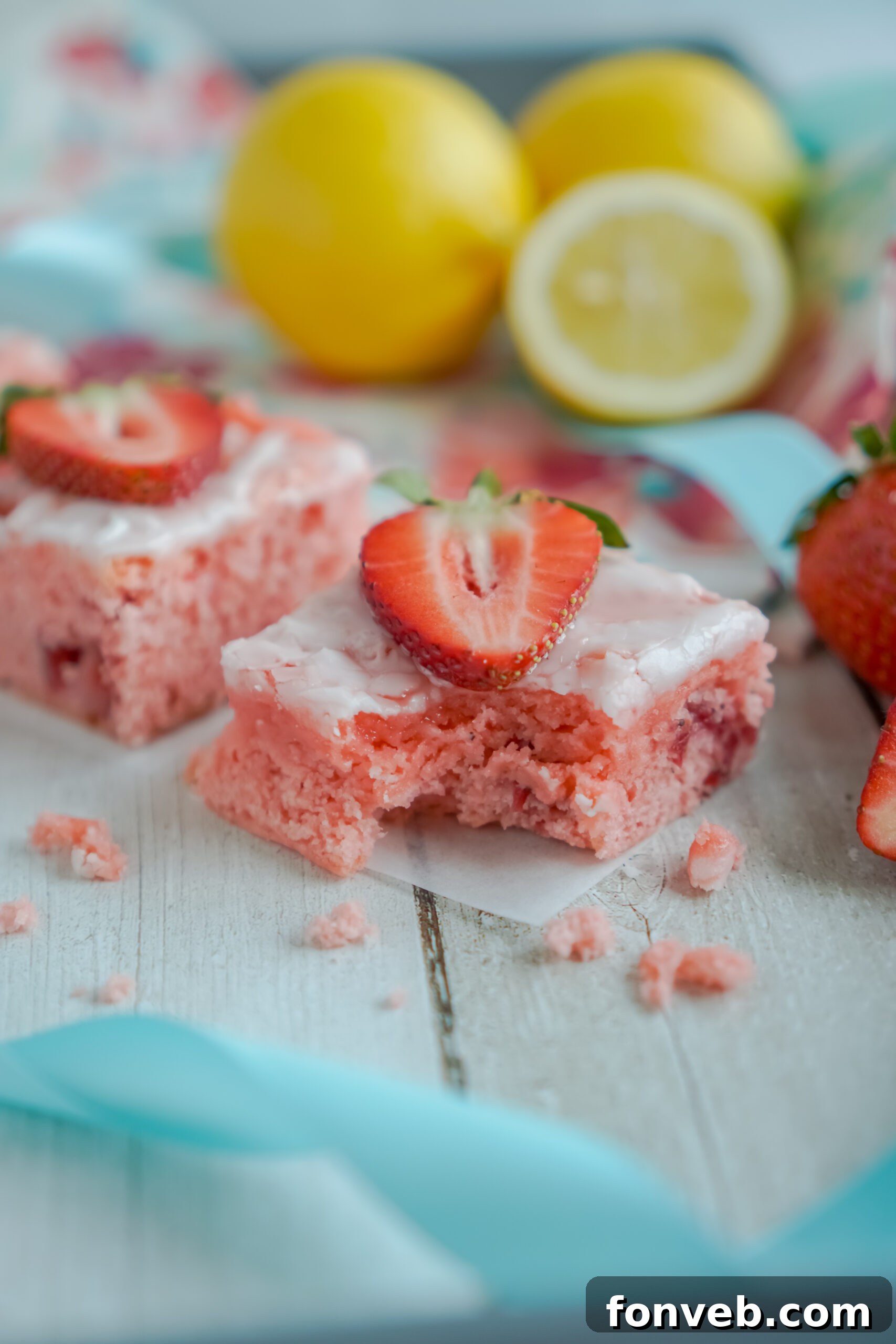 Front view of several Strawberry Lemon Brownies arranged neatly on parchment paper.