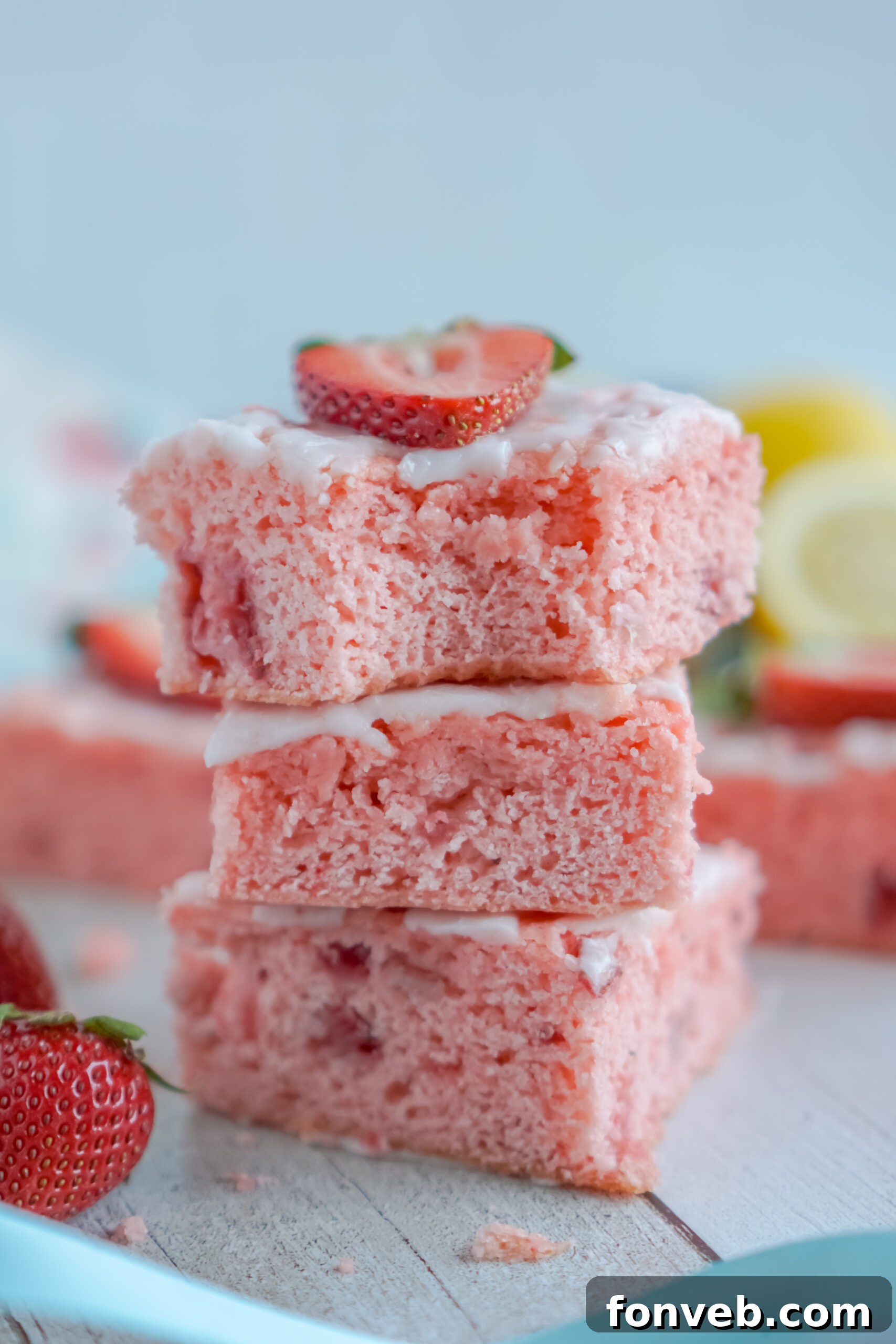 Three Strawberry Lemon Brownies stacked, with the top brownie showing a perfect bite mark.