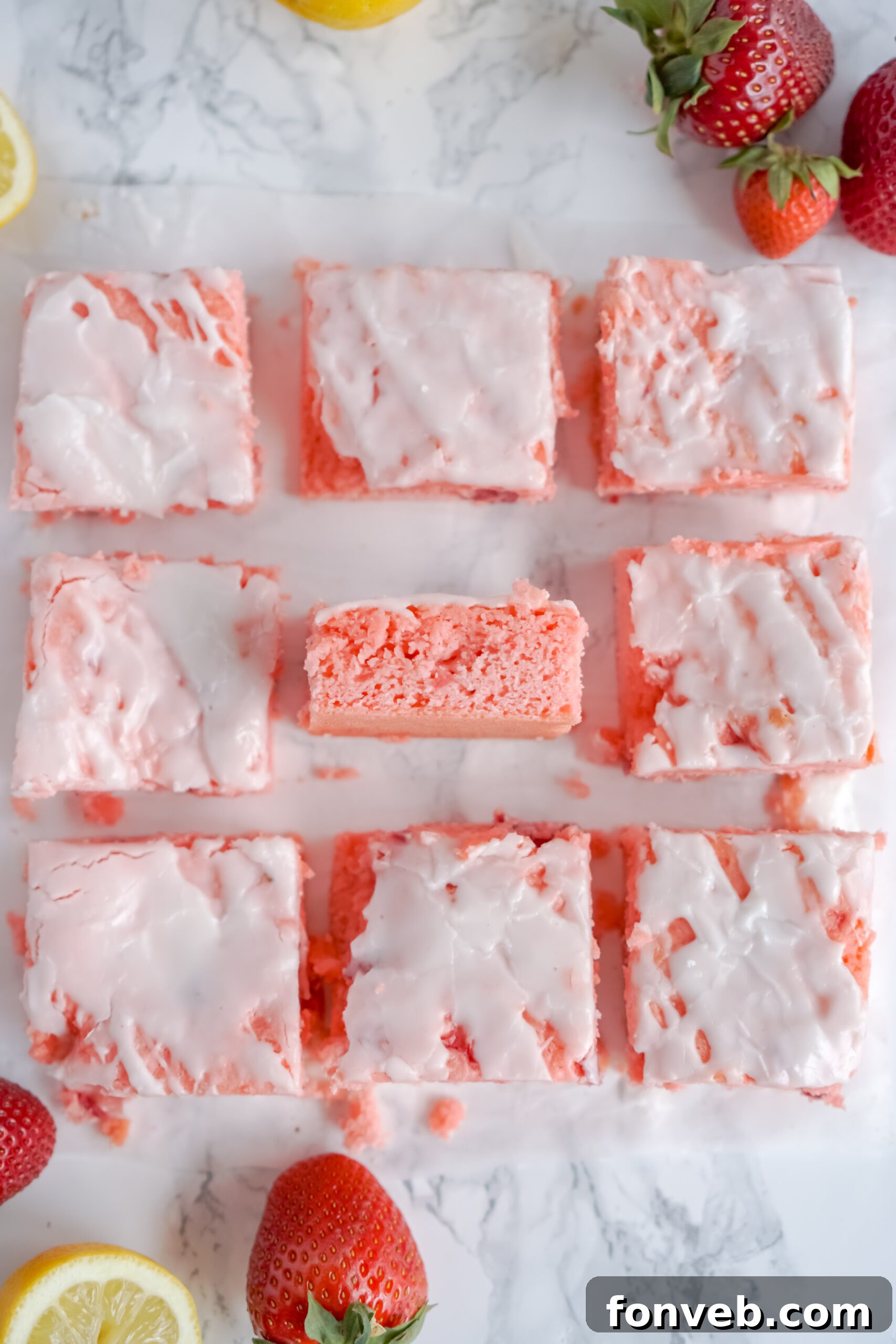 Overhead shot of freshly baked Strawberry Lemon Brownies on parchment paper, ready for slicing.