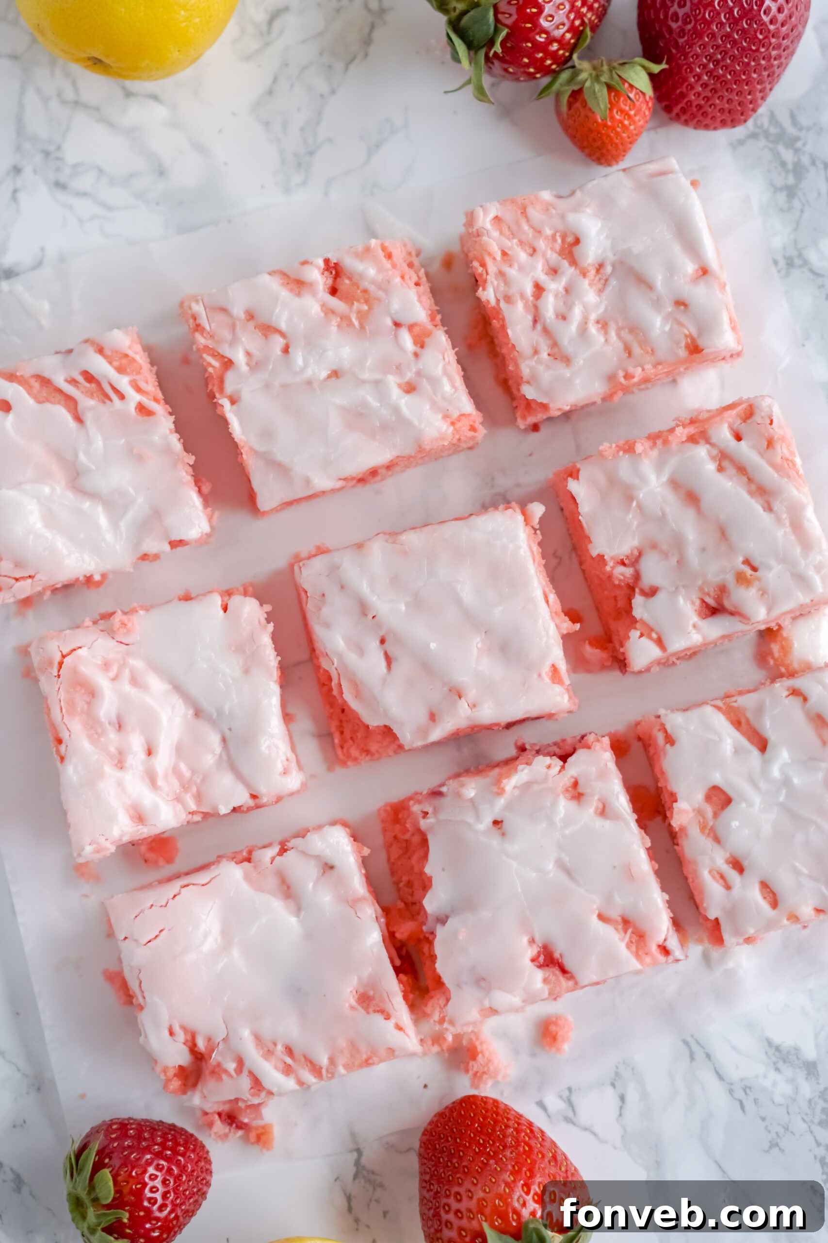 Close-up overhead view of Strawberry Lemon Brownies on parchment paper, highlighting their vibrant color.