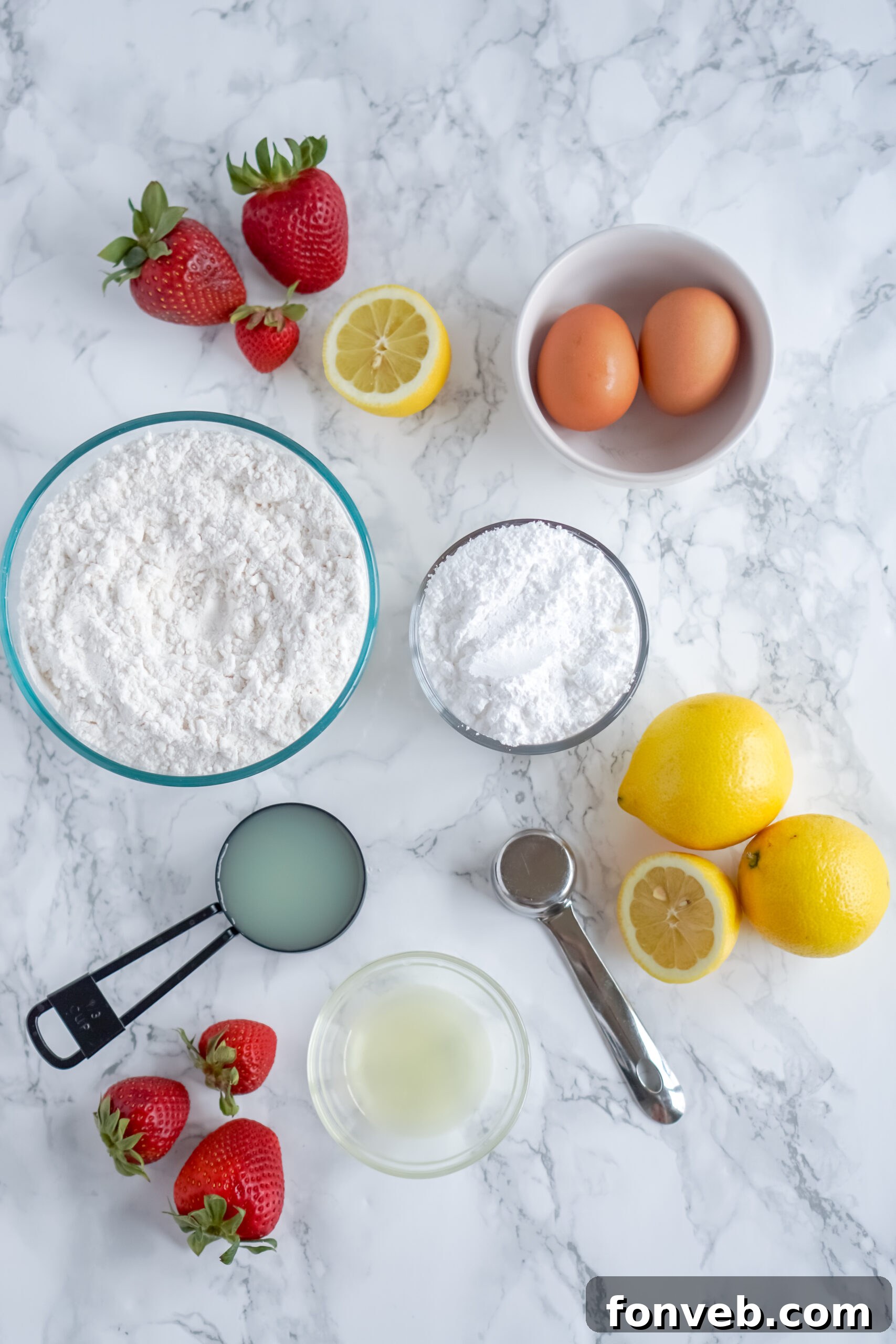 All the core ingredients for Strawberry Lemon Brownies laid out on a table: cake mix, fresh strawberries, lemon juice, and eggs.