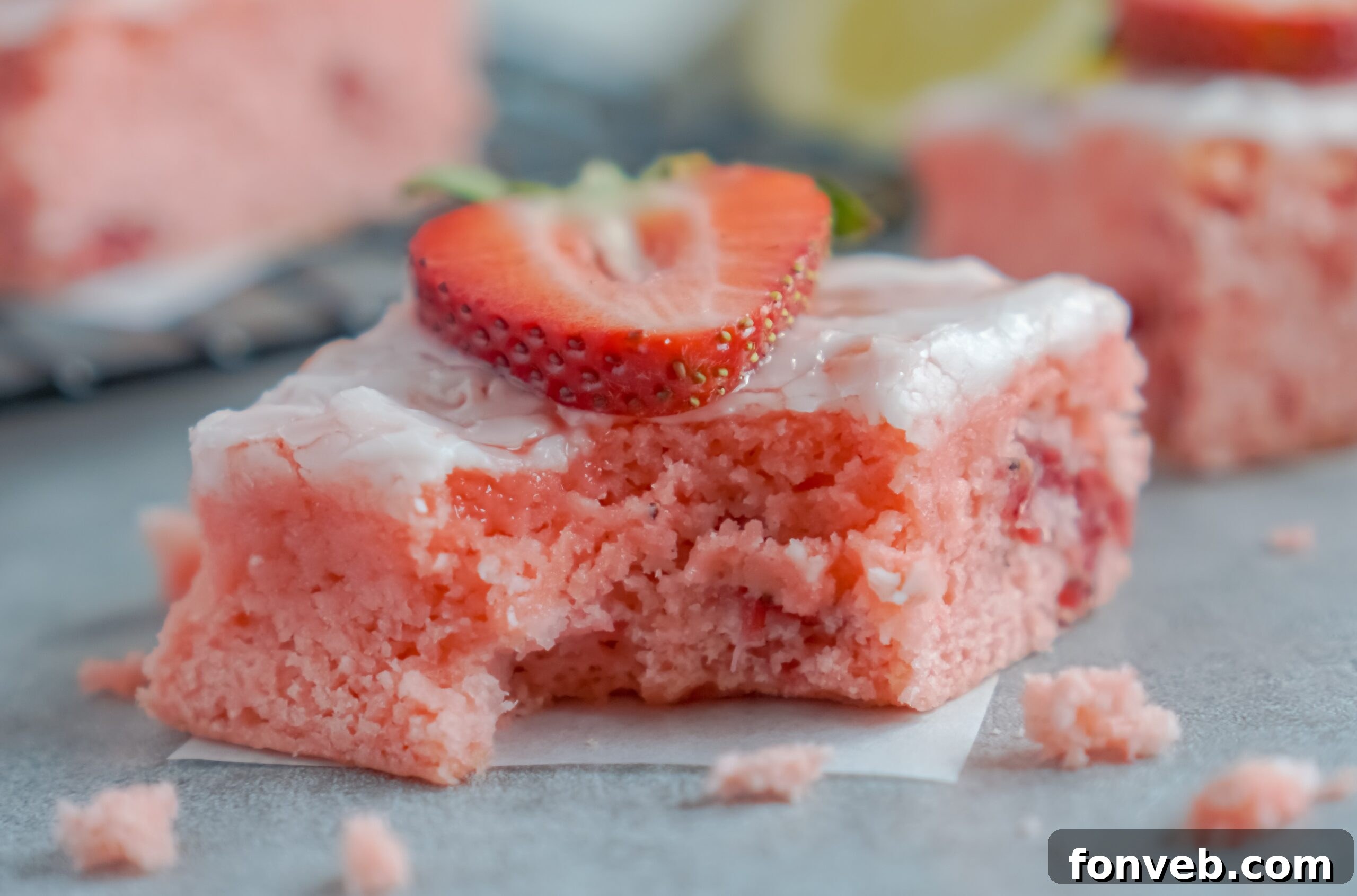 A single Strawberry Lemon Brownie with a bite missing, showing the thick, vibrant lemon glaze.