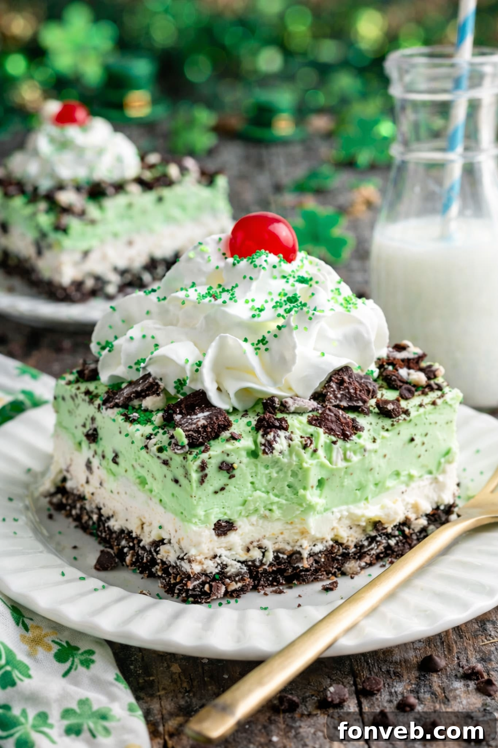 Emerald Lasagna 2 A stunning slice of Shamrock Lasagna dessert on a white plate, adorned with St. Patrick's Day themed decorations.
