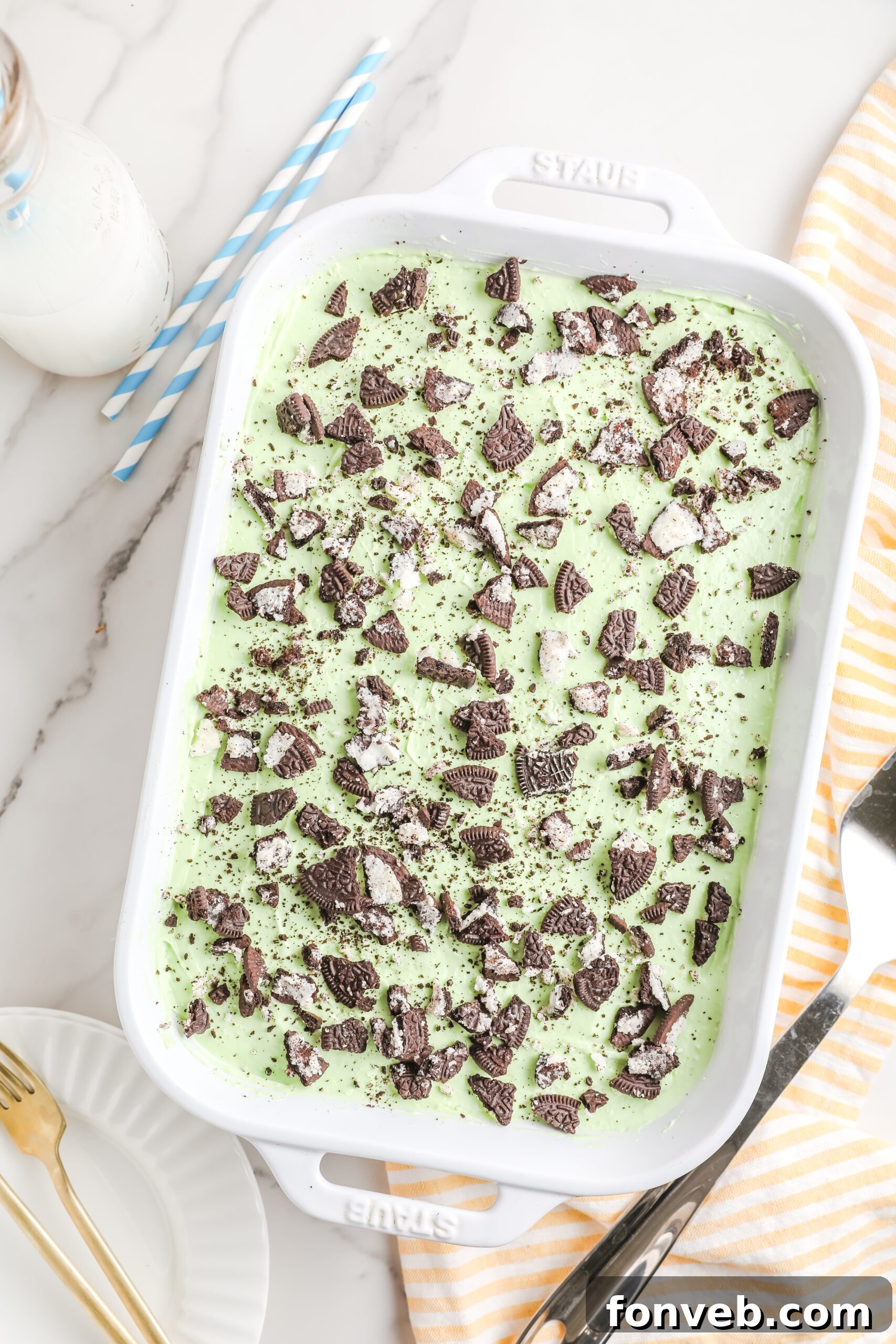 Emerald Lasagna 3 Overhead view of a rectangular baking dish filled with Shamrock Lasagna, showcasing a generous topping of crushed Oreos, ready to be chilled.