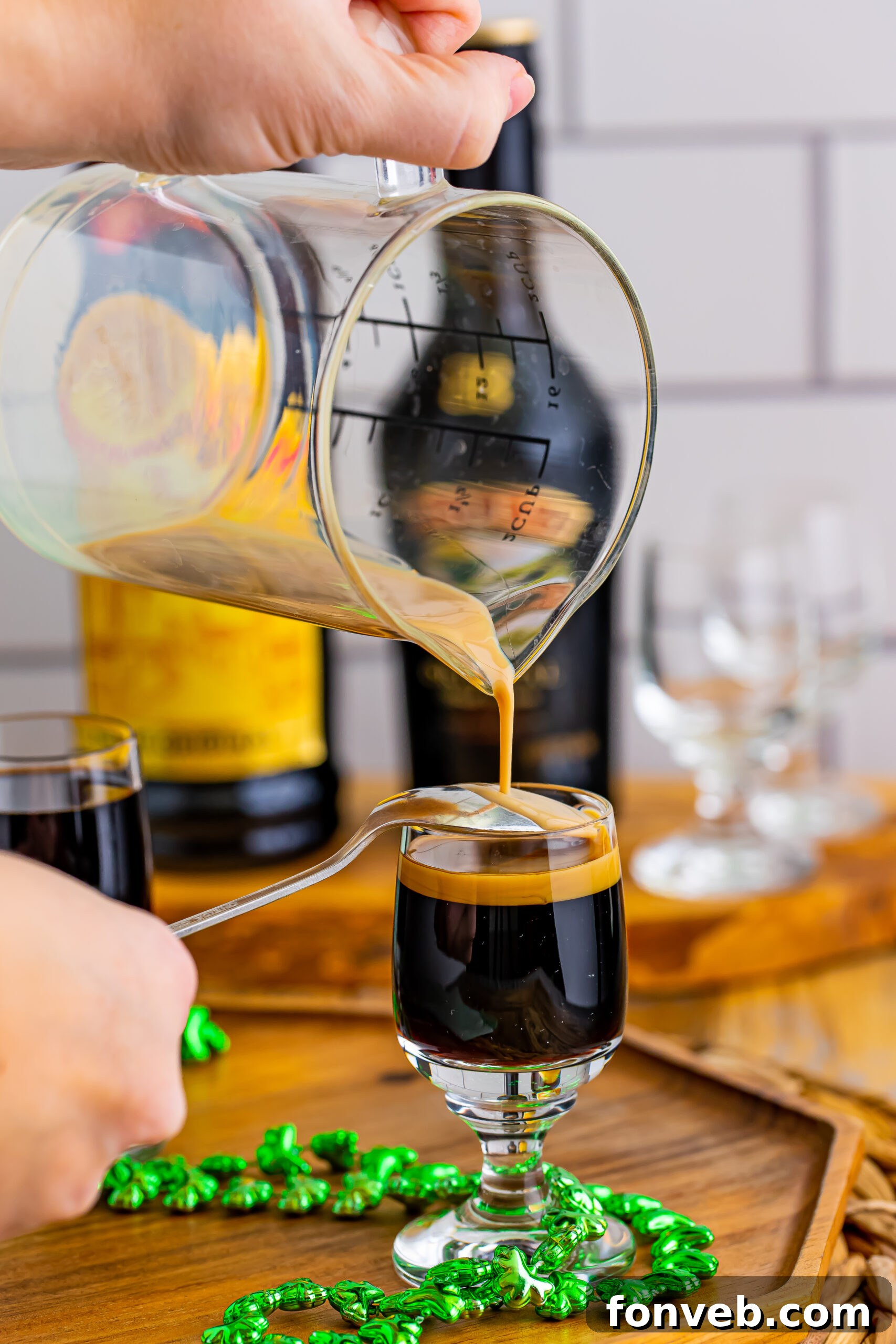 Mock Guinness Shots 10 Pouring the Bailey's Irish cream over a spoon into the shot glass.
