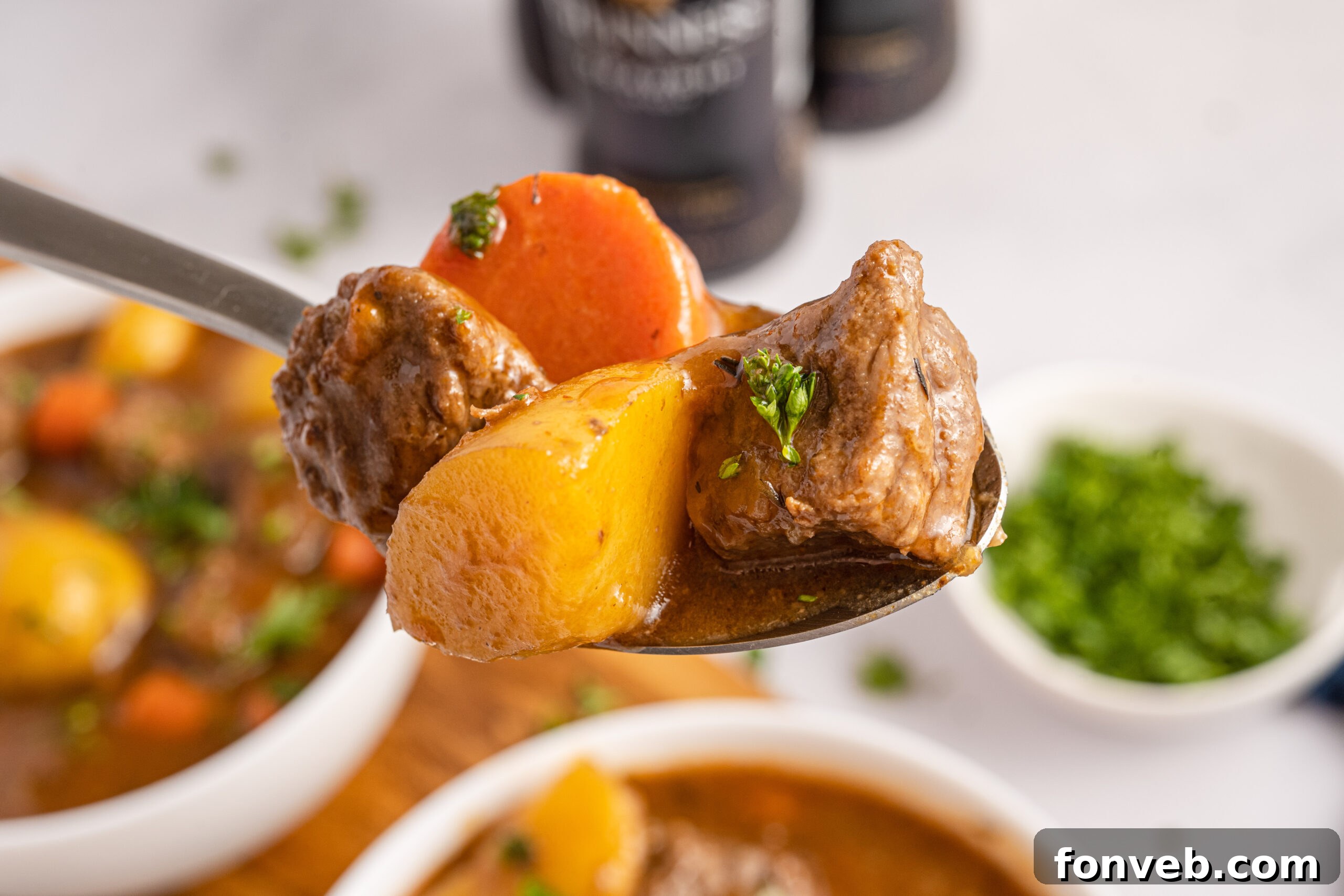 Two bowls of Irish stew  with a spoon lifting up a bite