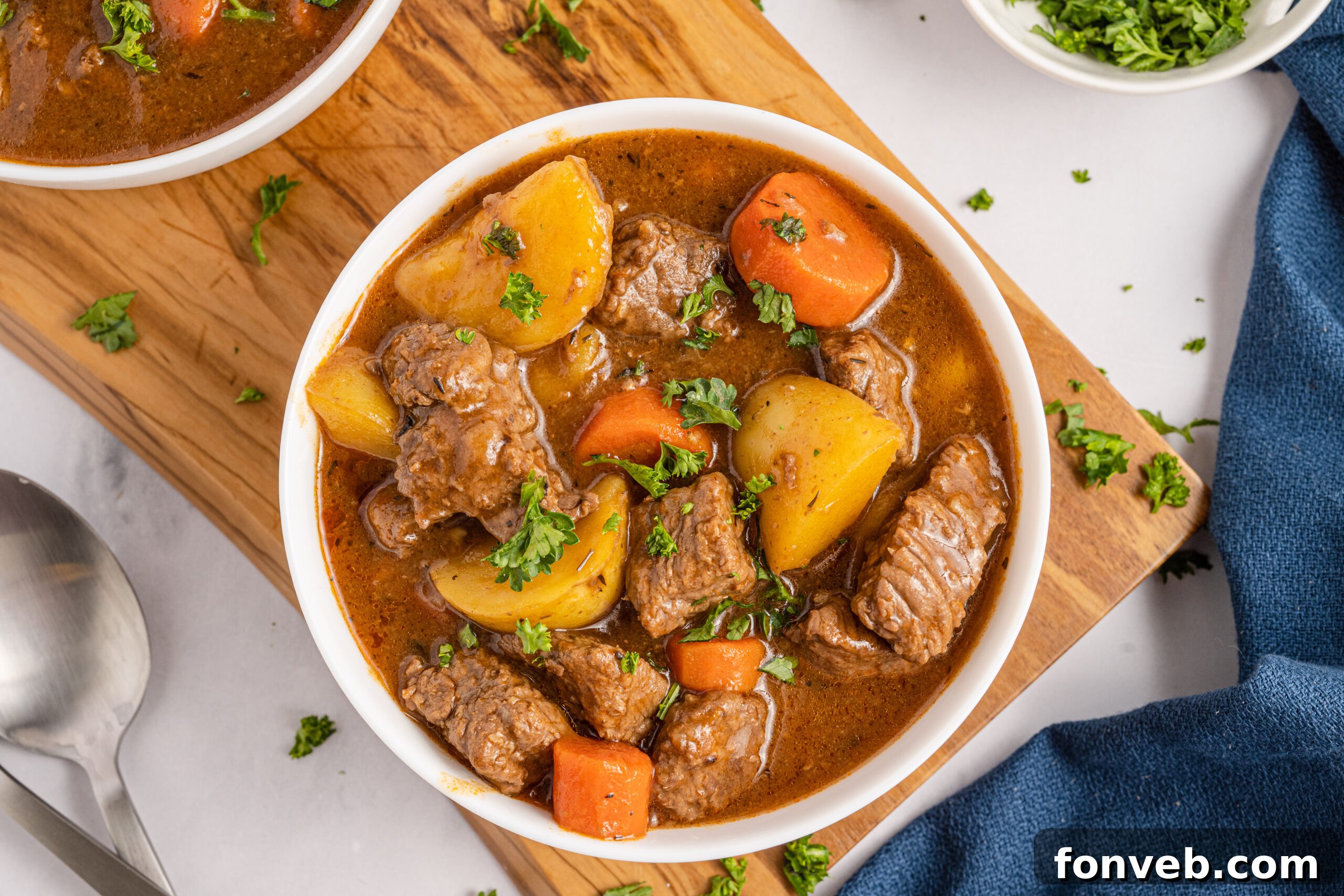 Overhead shot of Two bowls of Irish stew sitting on a wooden board 