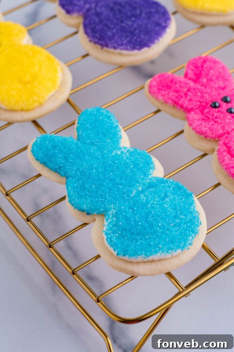 An Easter bunny cookie after being expertly dipped in blue sprinkles, showcasing its bright, colorful finish.