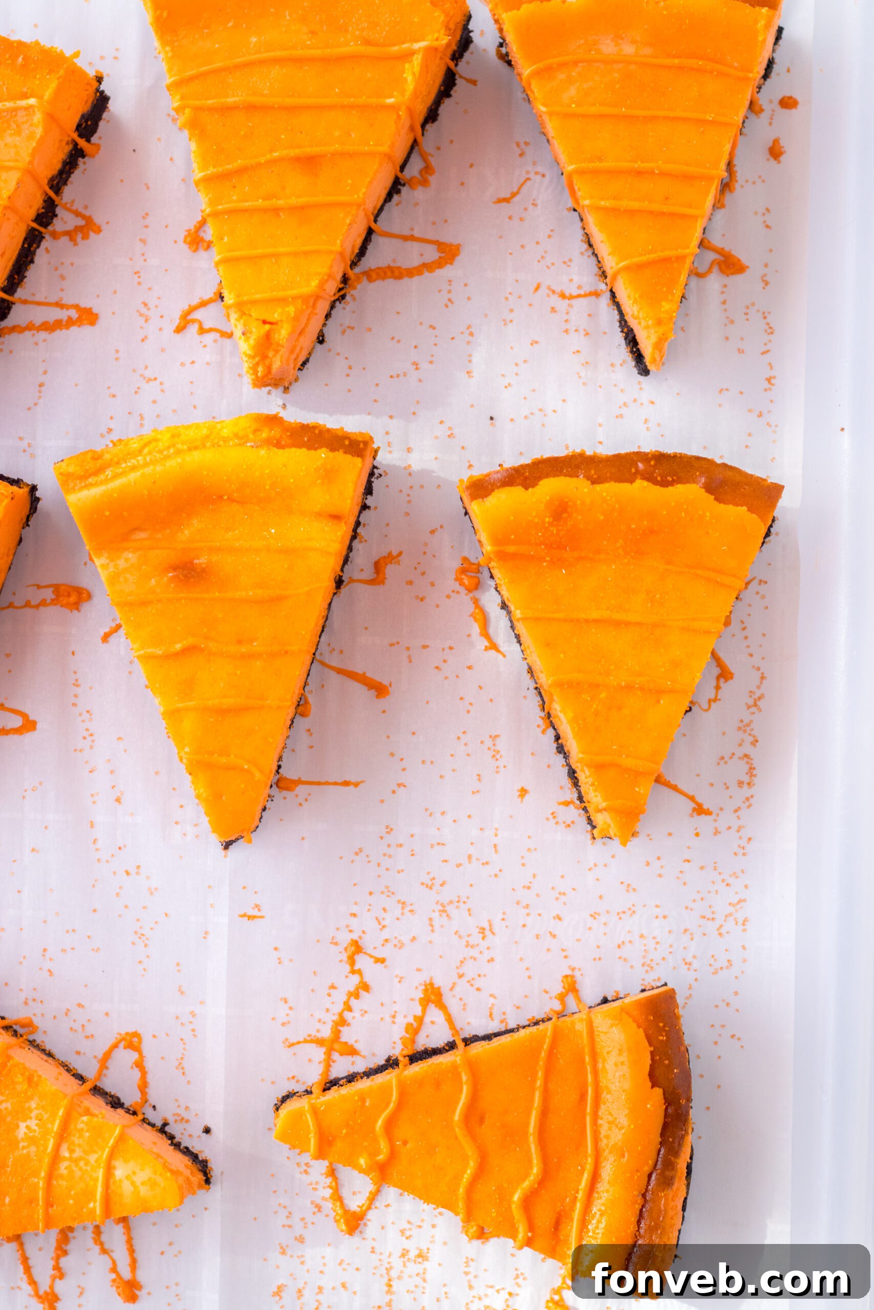 An inviting overhead view captures the intricate process of drizzling orange candy melts over the cheesecake carrots, adding the final touch to their festive design.