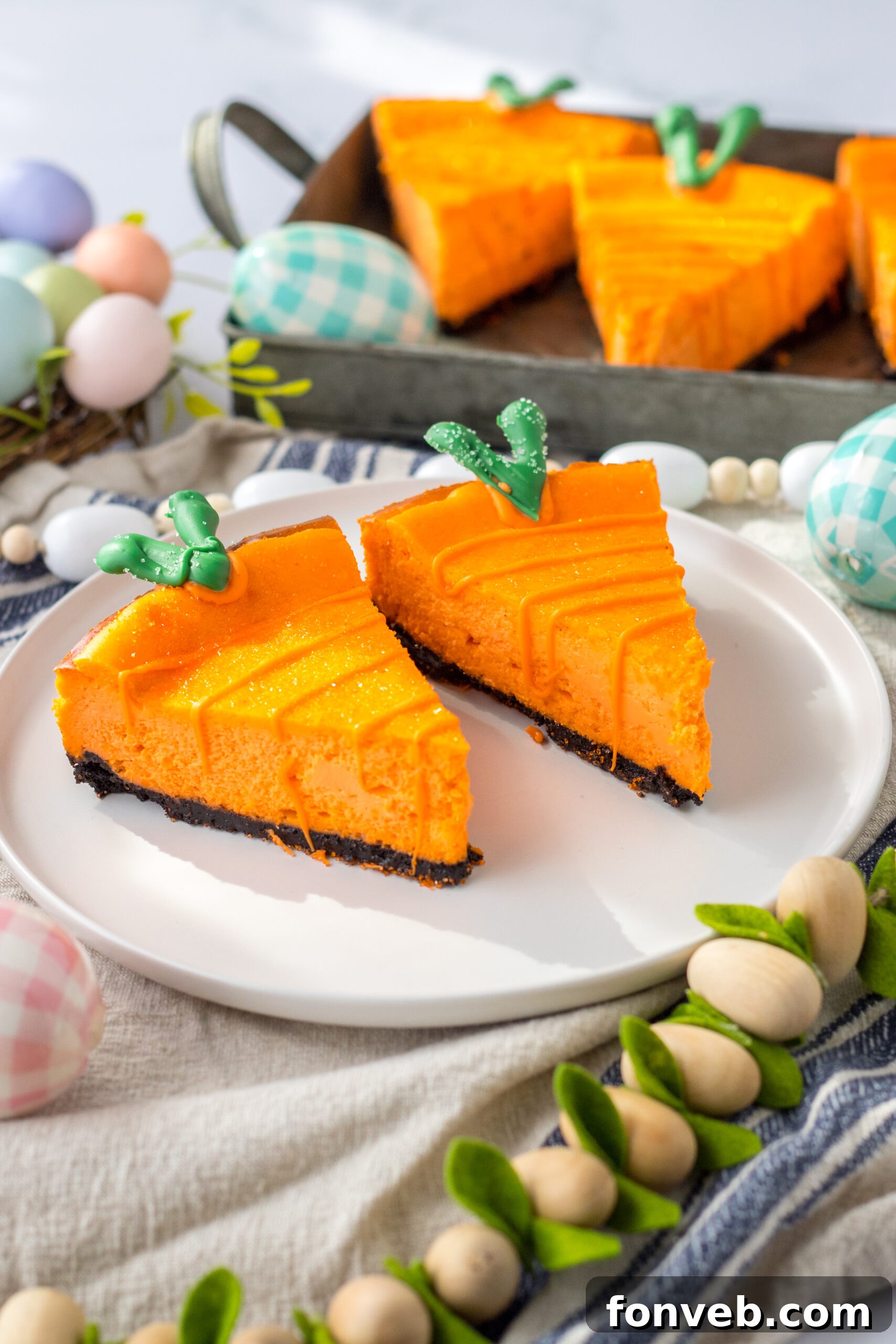 Two charming cheesecake carrots rest elegantly on a white plate, ready to be enjoyed.