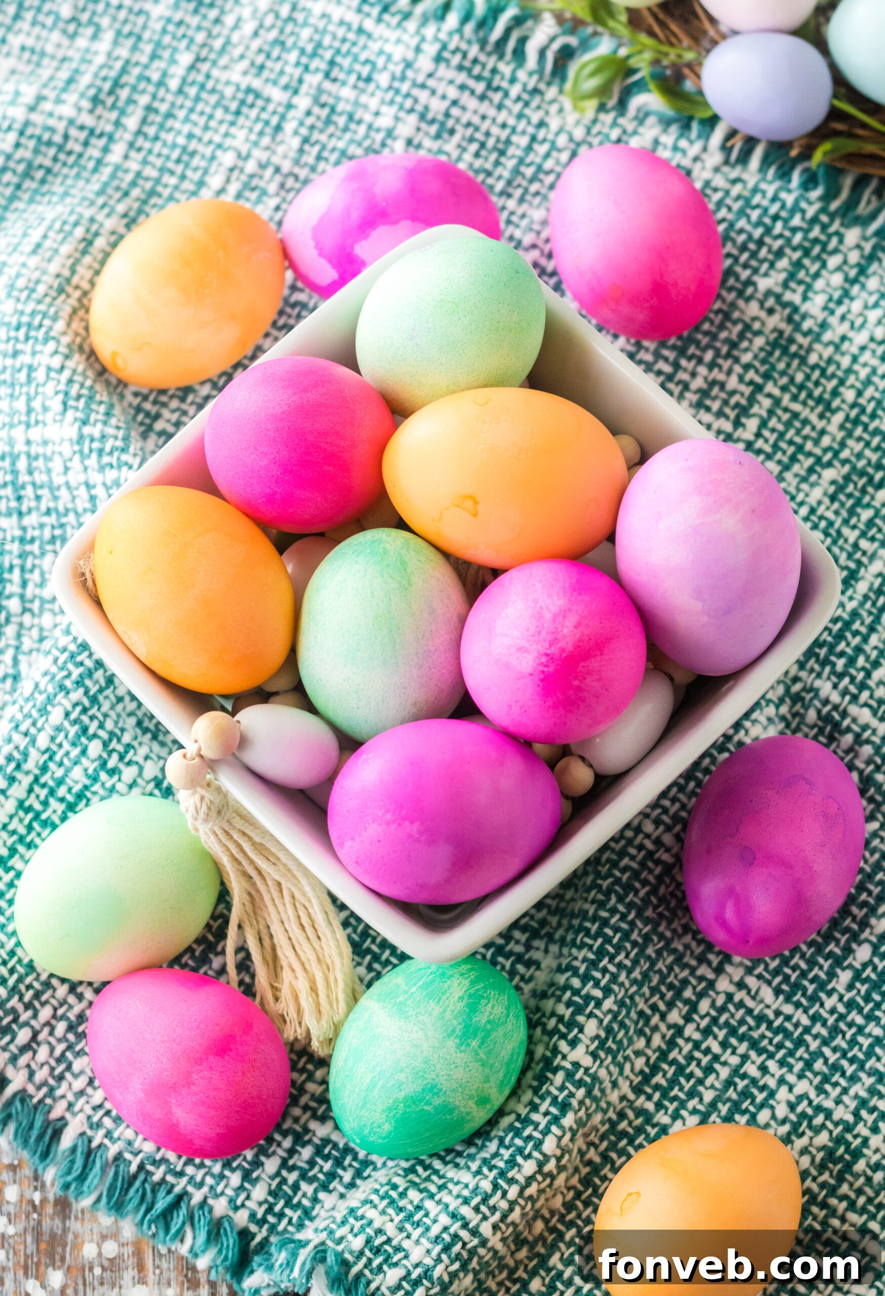 Overhead view of Dyed Easter Eggs in a white glass container. 