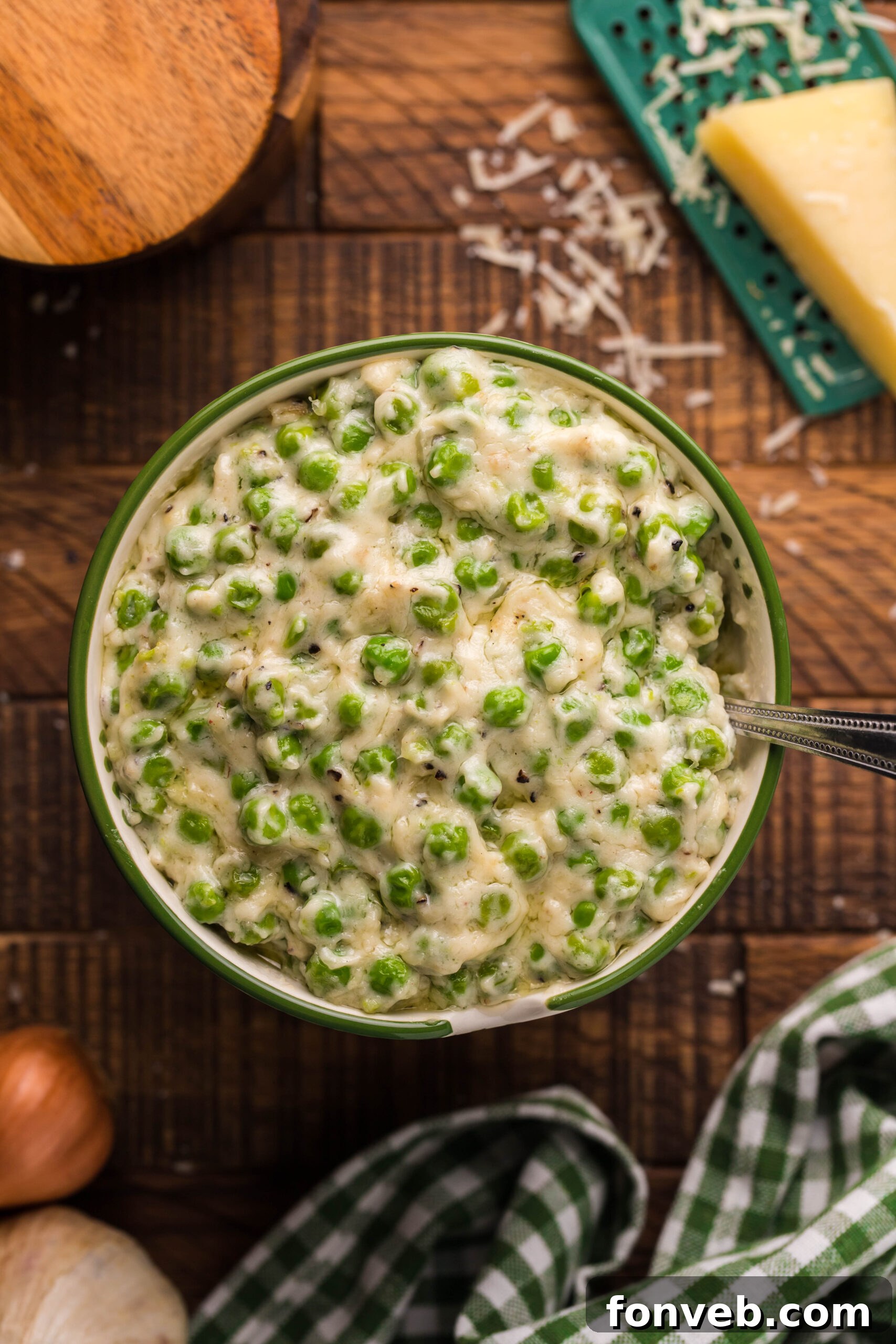 Overhead shot of creamed peas in a green and white bowl. 