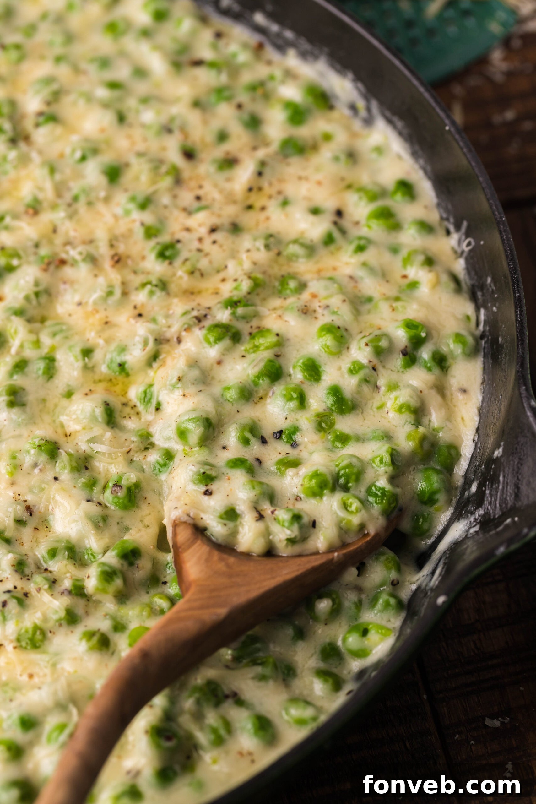 Creamed peas in a green and white bowl.