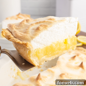 homemade lemon meringue pie slice being lifted