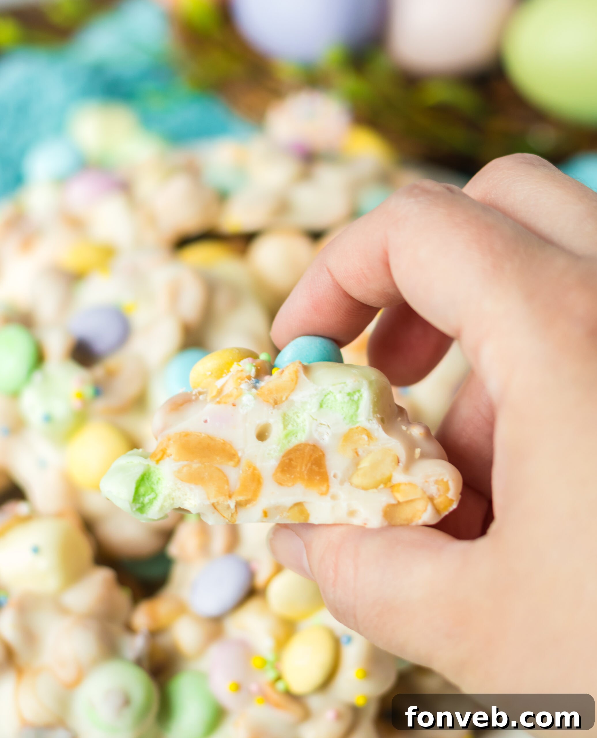A hand holding a piece of Easter candy with a bite removed.