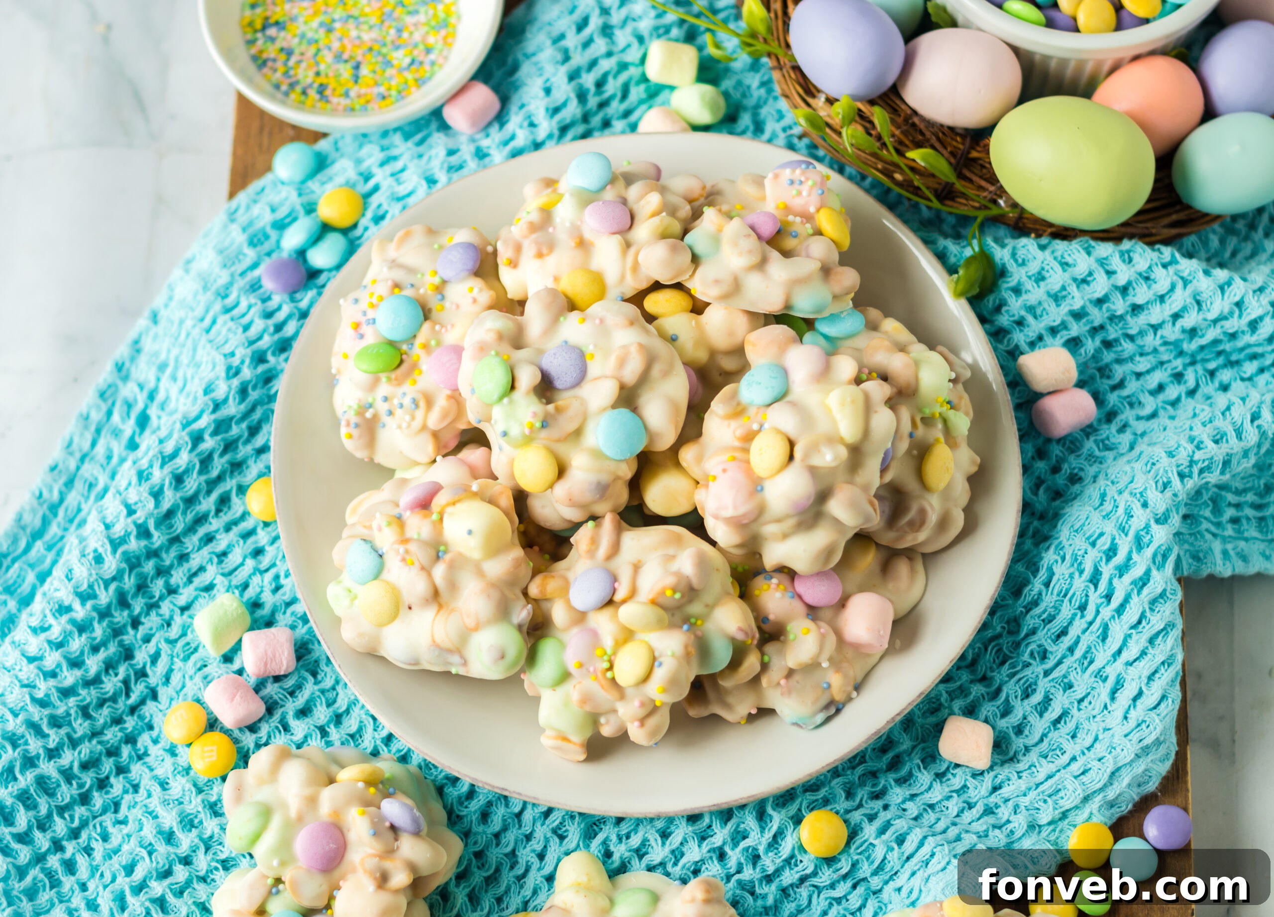 Overhead view of the slow cooker Easter candy on a white plate on a teal linen.