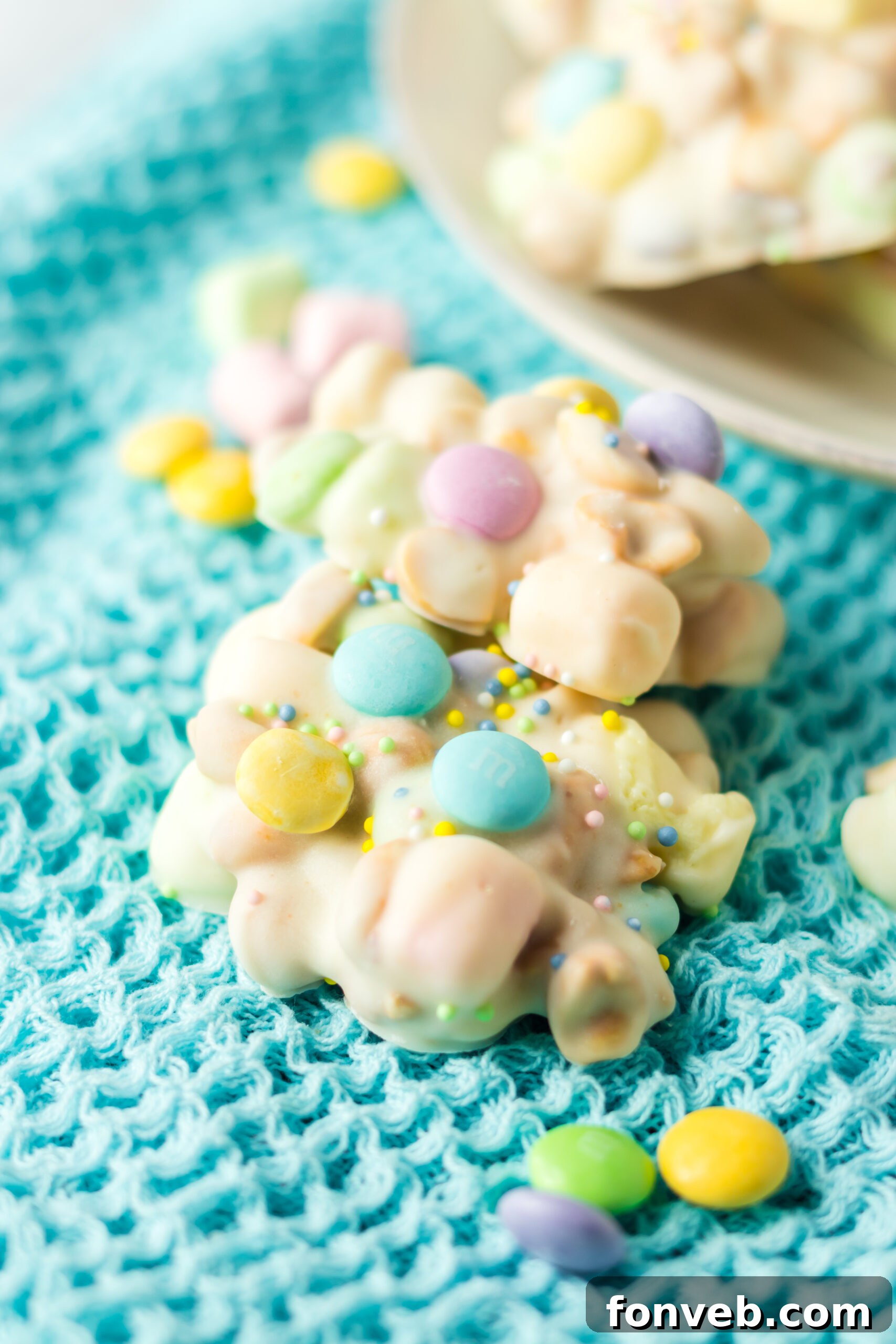 Two pieces of slow cooker Easter candy on a teal linen.