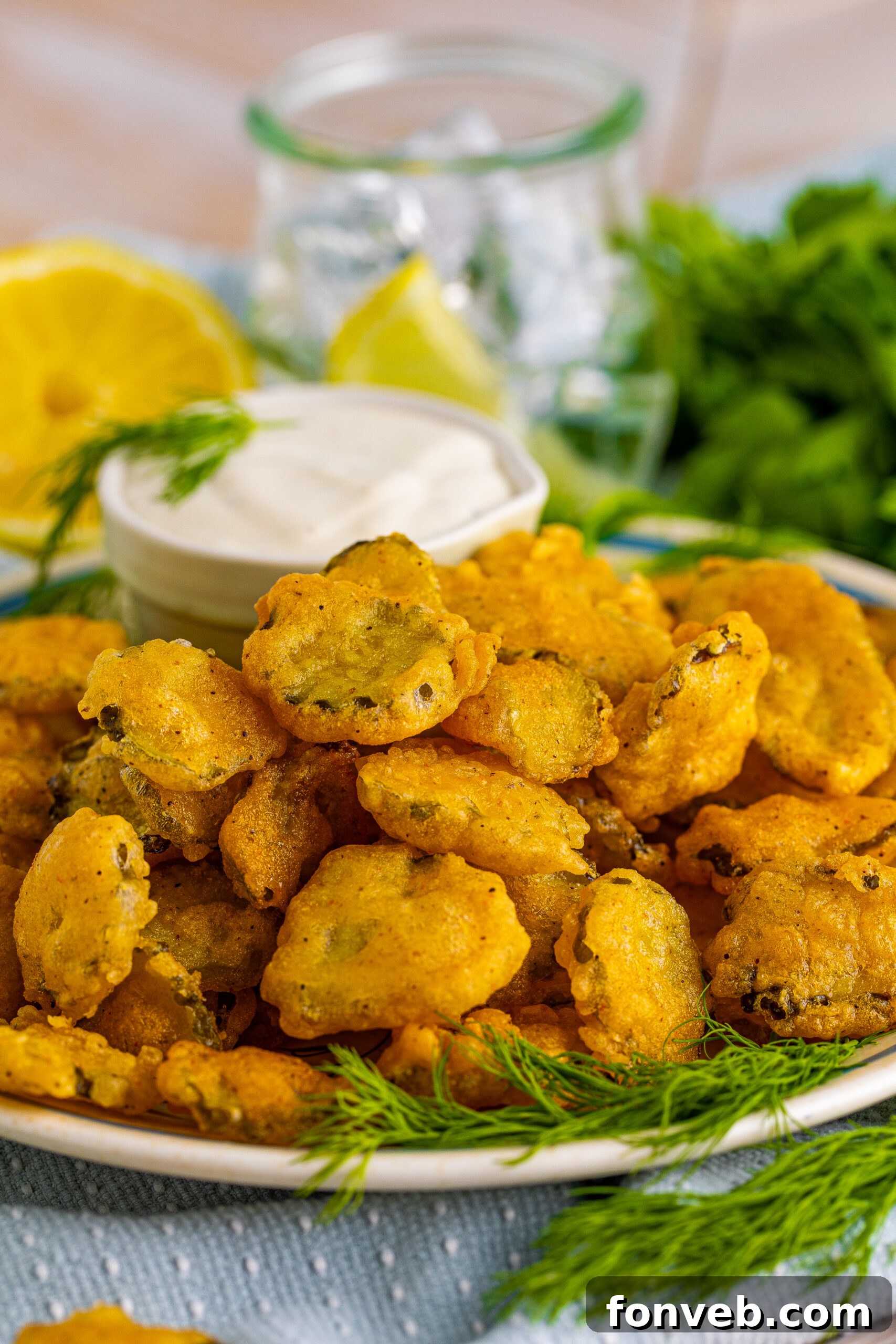 Fried Pickles on a white plate with ranch and fresh dill in the background. 