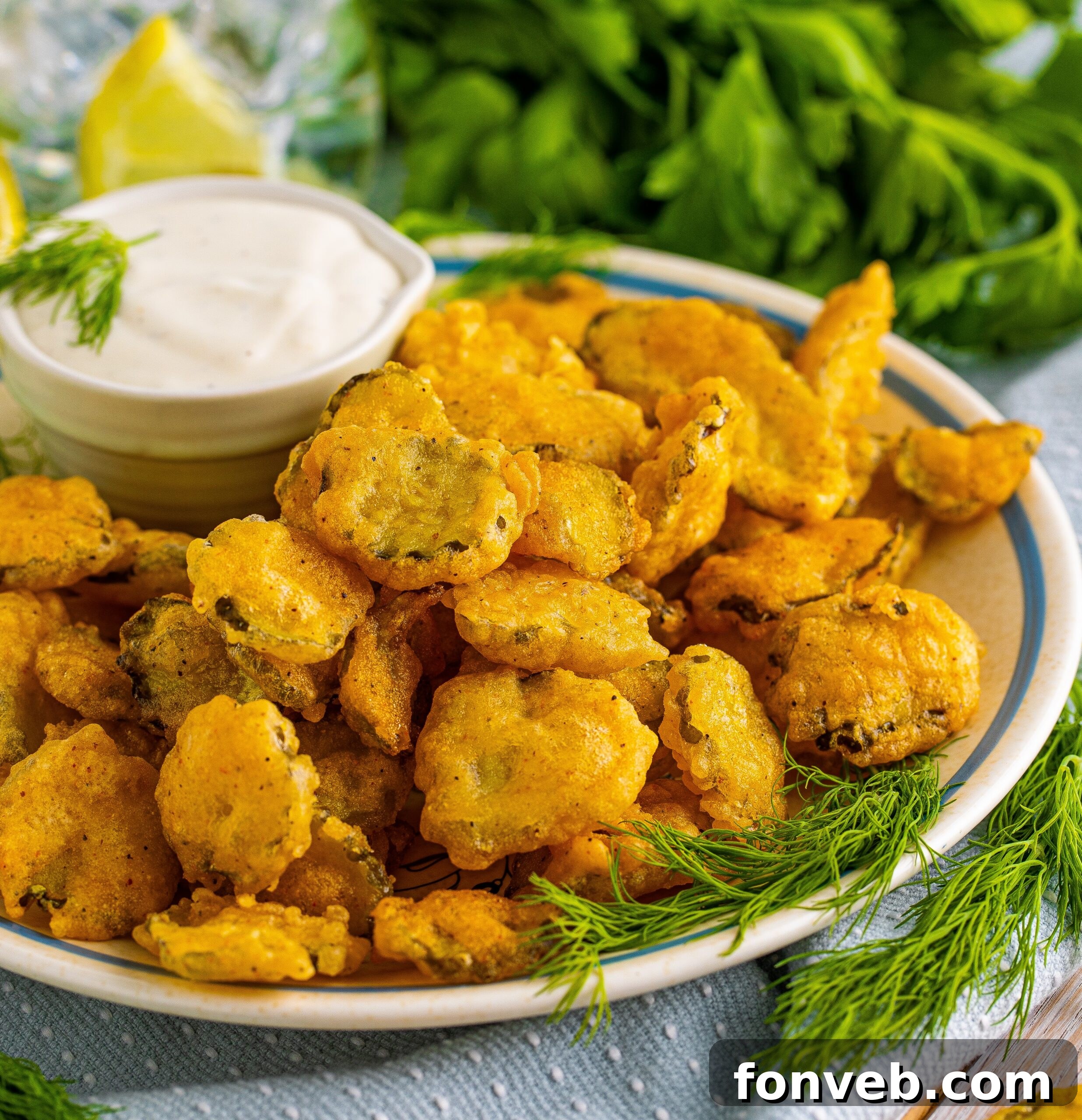 Fried Pickles on a white plate with ranch and fresh dill in the background. 