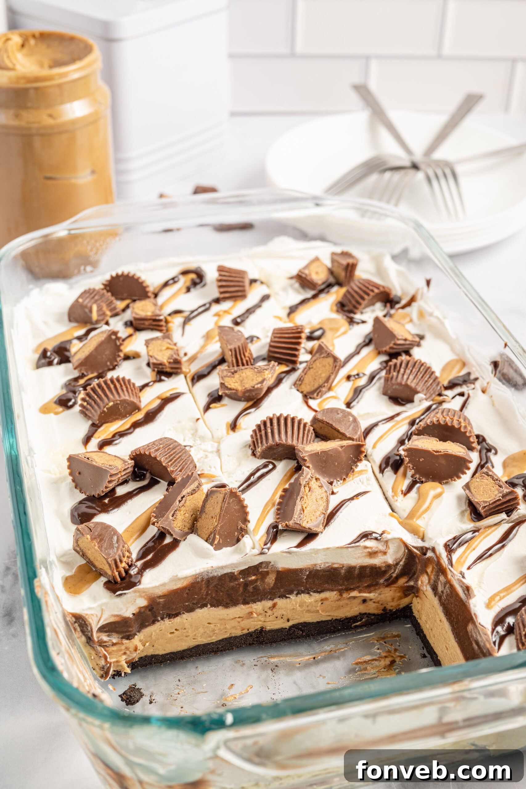 Reese's Peanut Butter Cup Lasagna 3 A glass baking pan showcasing a full Reese's chocolate peanut butter lasagna with two perfect slices already removed, ready for serving.