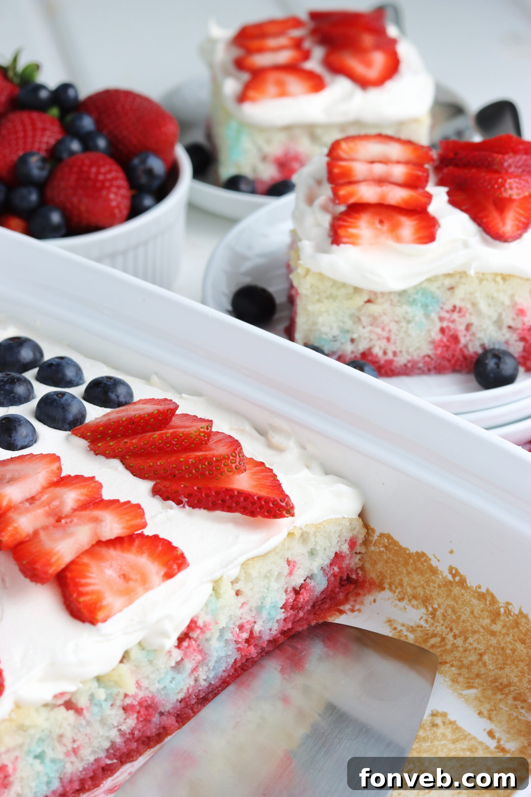 Another perspective of a single slice of American Flag Cake on a white plate.