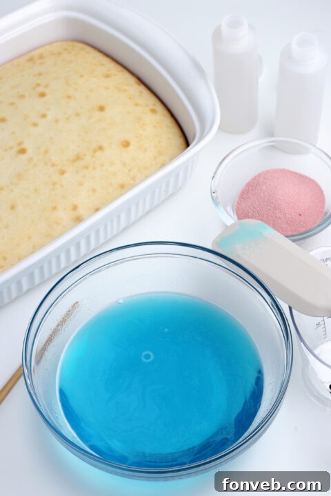 Red gelatin being poured into the holes of the cake.