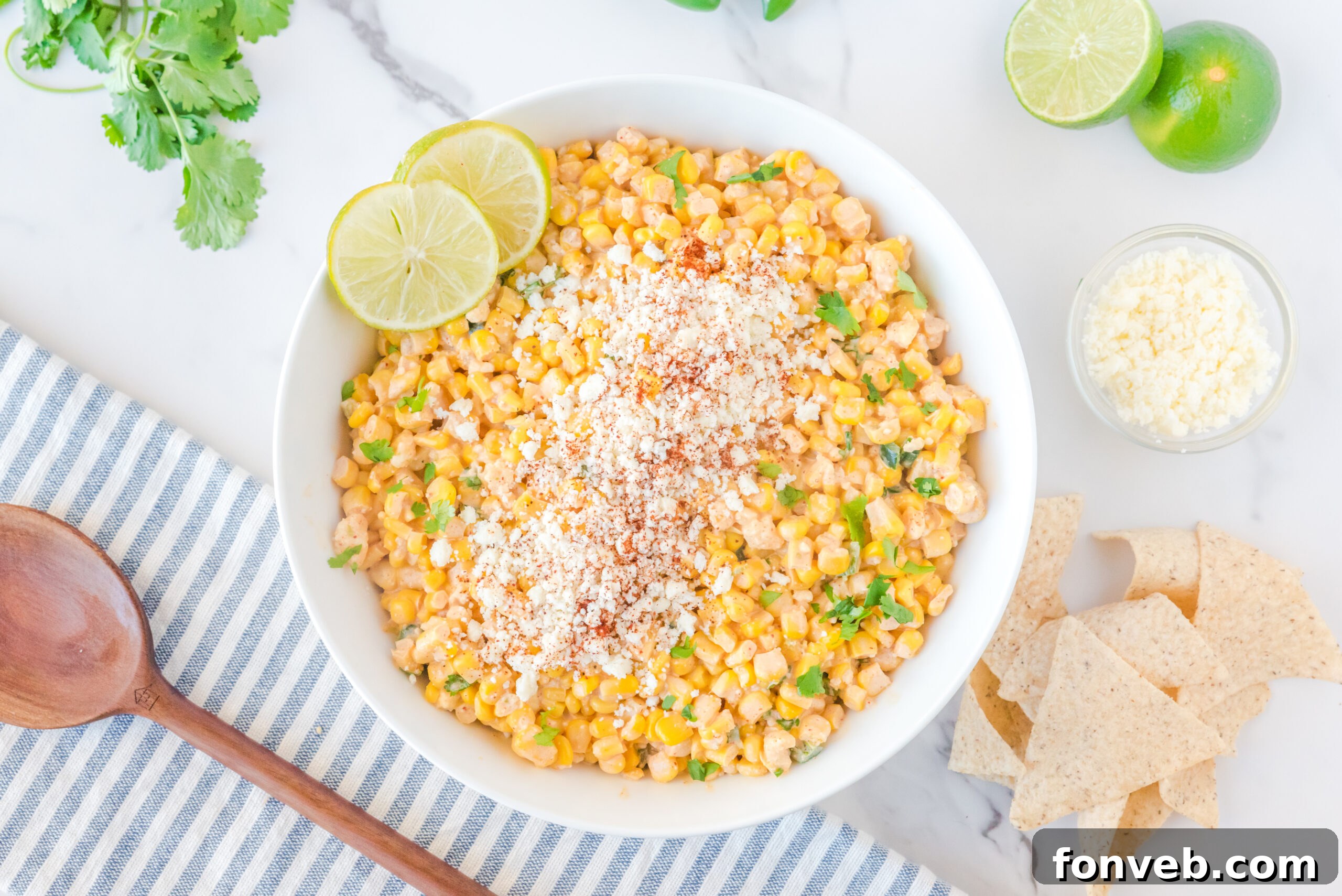 A large white serving bowl prominently featuring the delicious Mexican Street Corn Salad, ready to be enjoyed.