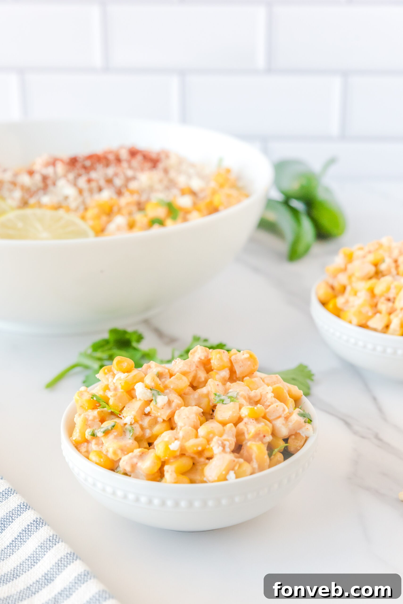 A small white serving bowl perfectly portioned with the delectable Mexican Street Corn Salad, ideal for an individual serving.