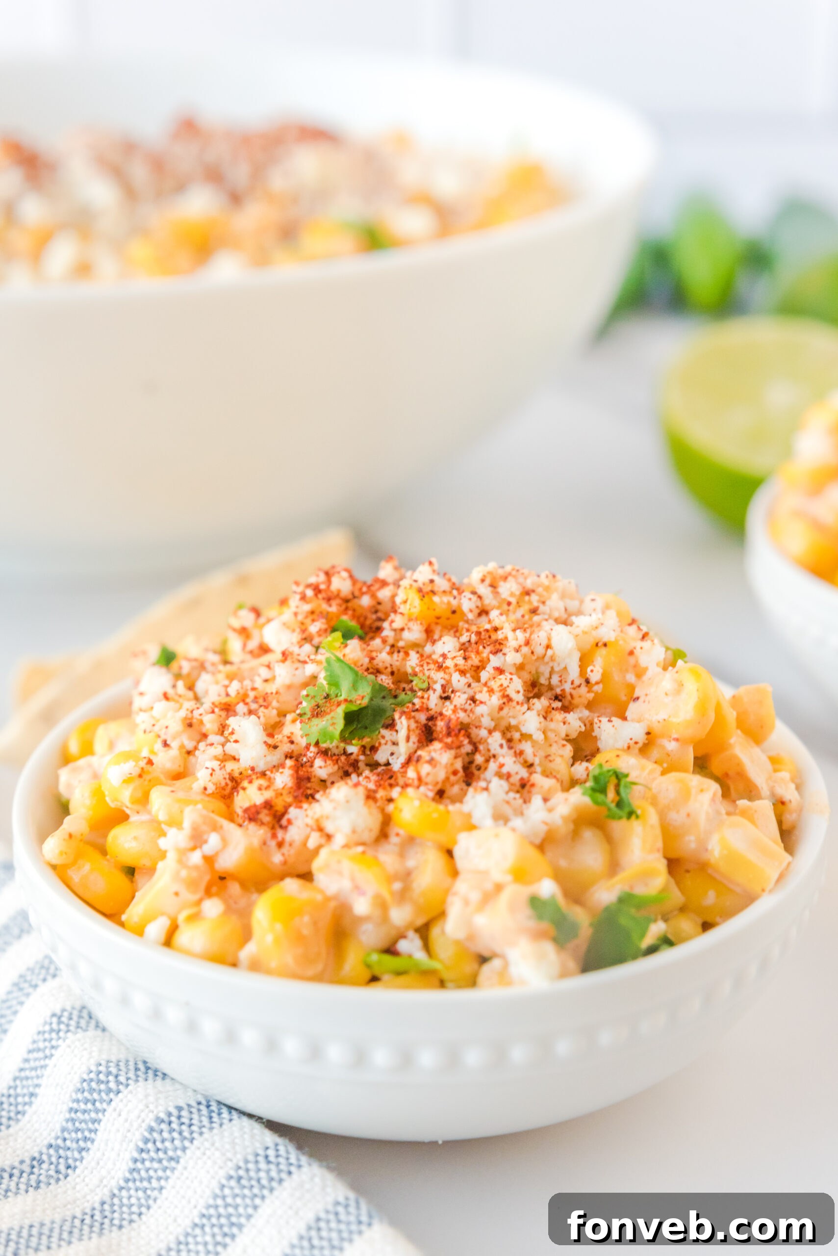Mexican Street Corn Salad beautifully presented in a white bowl, garnished with a sprinkle of paprika and fresh queso fresco.