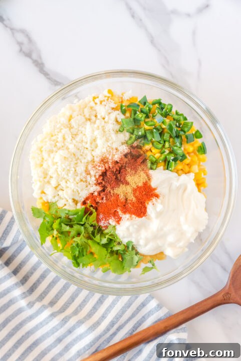 Minced garlic being added to the sautéing corn kernels in a skillet, releasing its fragrant aroma.