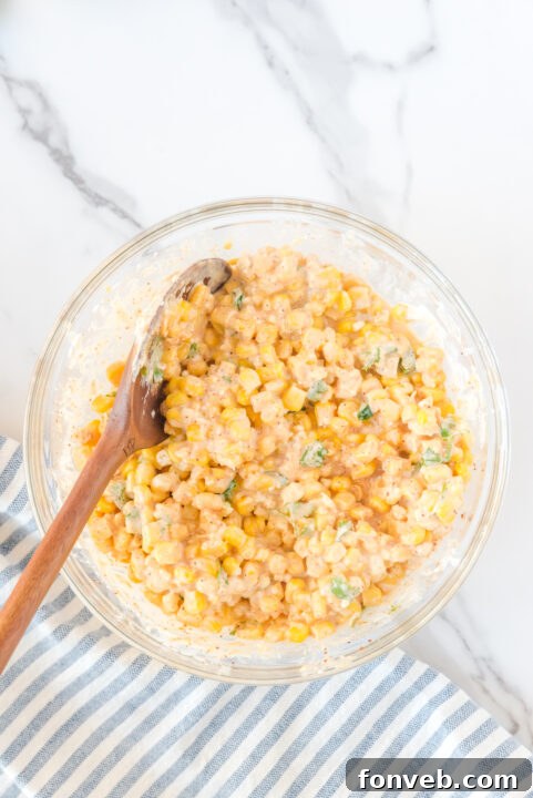 A mix of cooked corn and garlic cooling in a large mixing bowl, ready for the next ingredients.