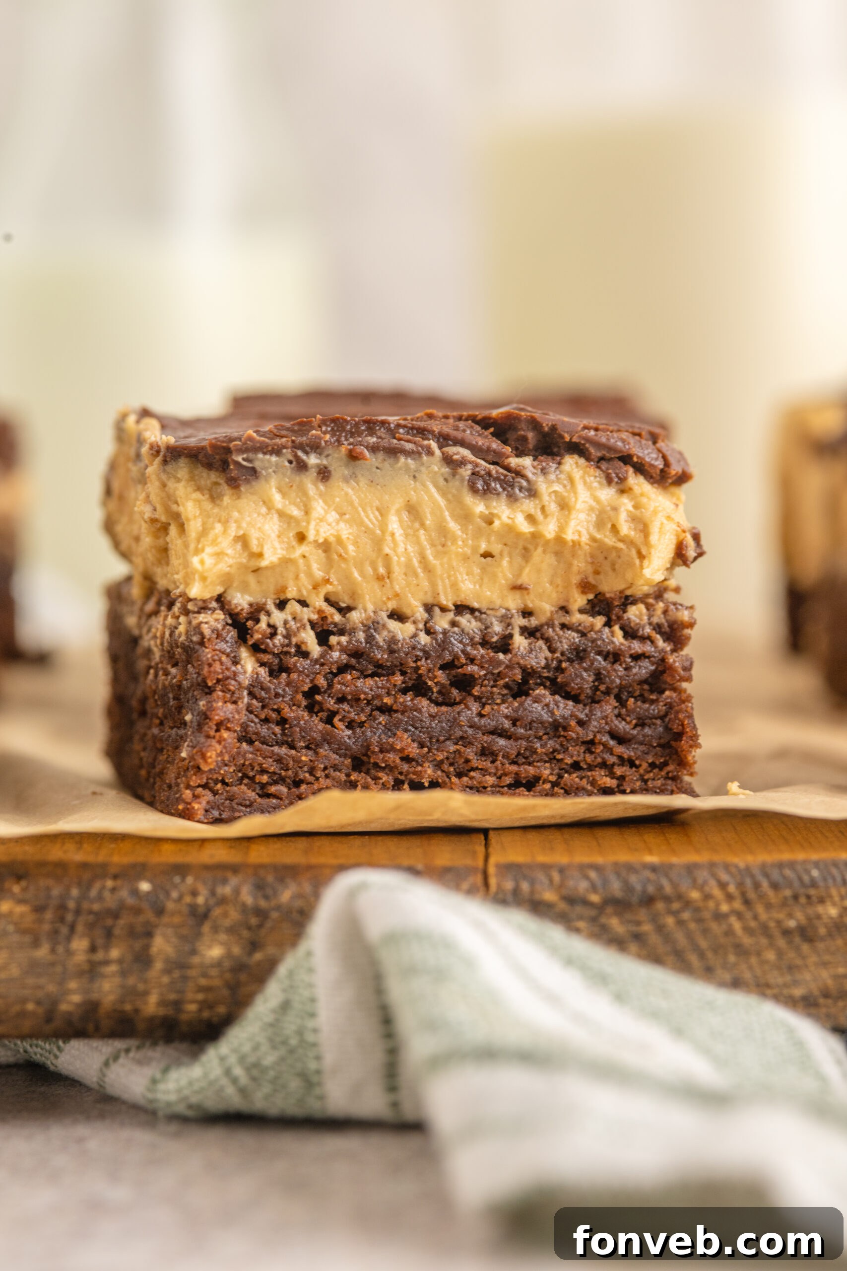Another beautiful side view highlighting the delectable layers of a Buckeye Brownie on a rustic wooden board.