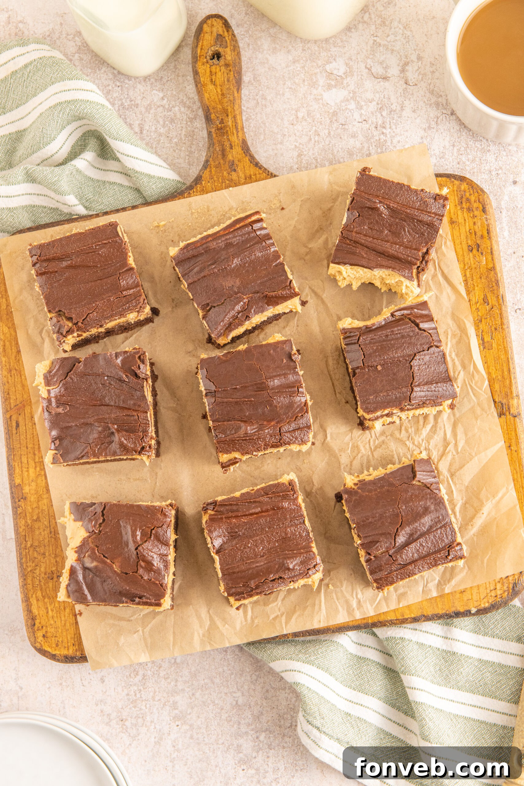 An overhead shot of freshly baked Buckeye Brownies artfully arranged on a rustic wooden serving board with parchment paper.