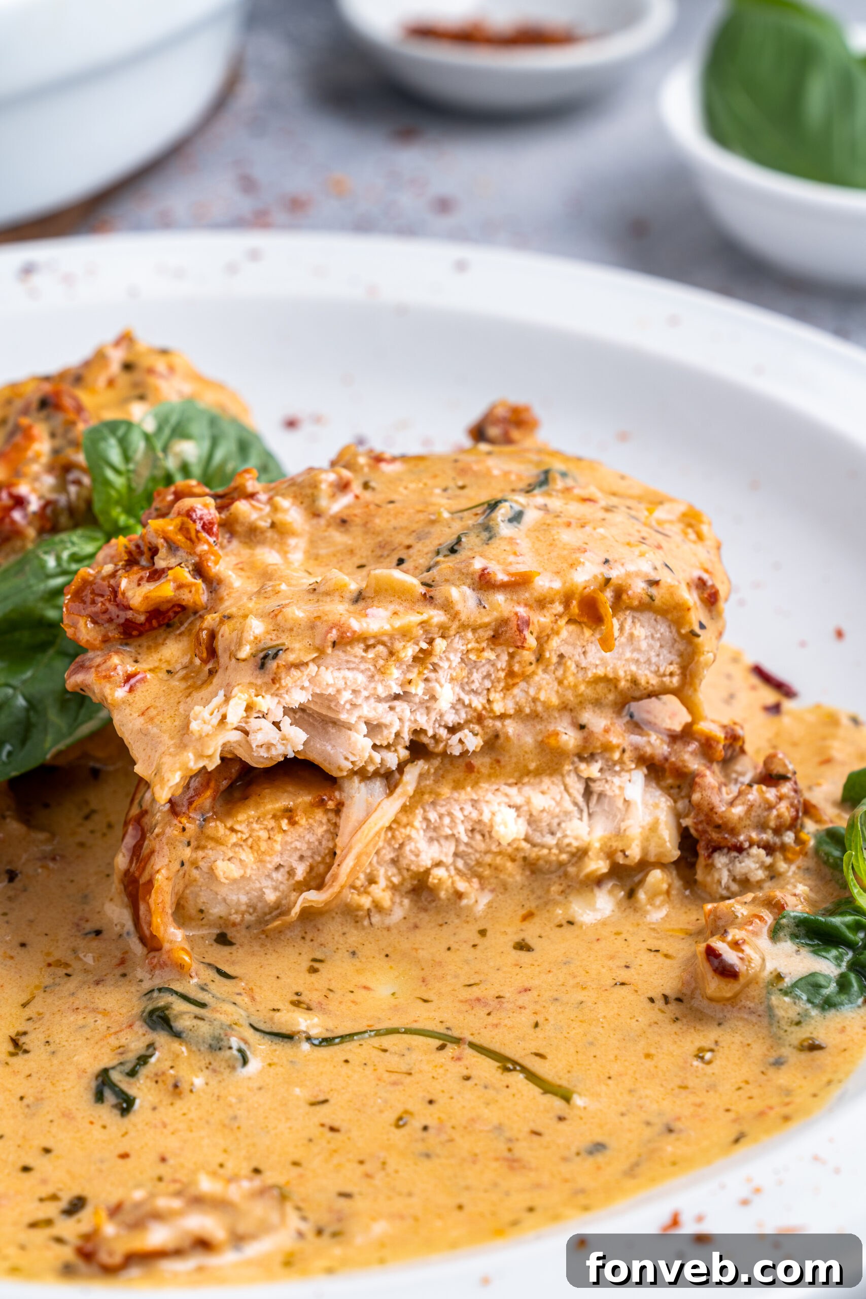 Dreamy Date Night Chicken 16 Marry Me chicken cut in half and stacked on top of each other on a white plate.