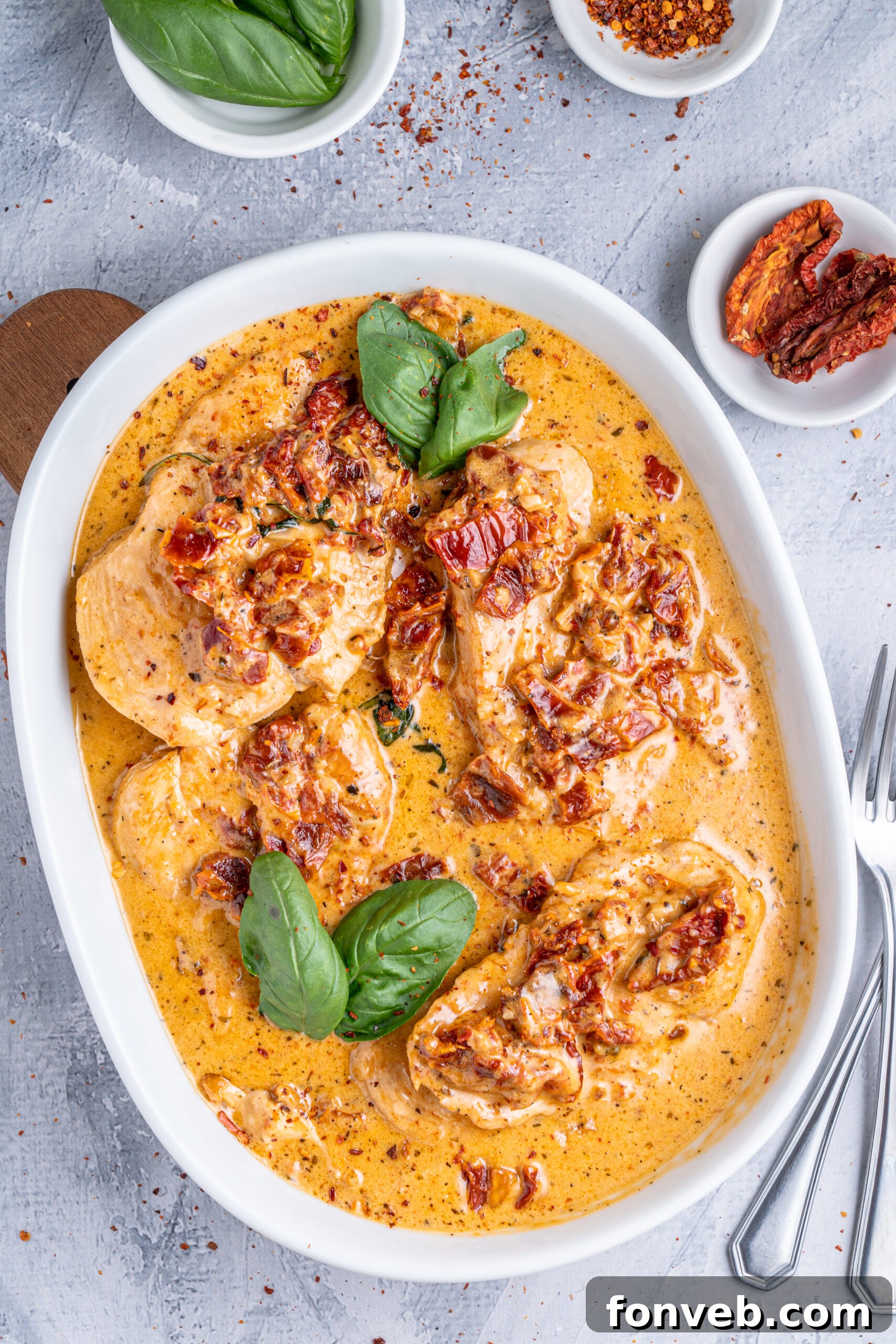 Dreamy Date Night Chicken 19 Marry Me Chicken in a white baking dish topped with fresh basil.