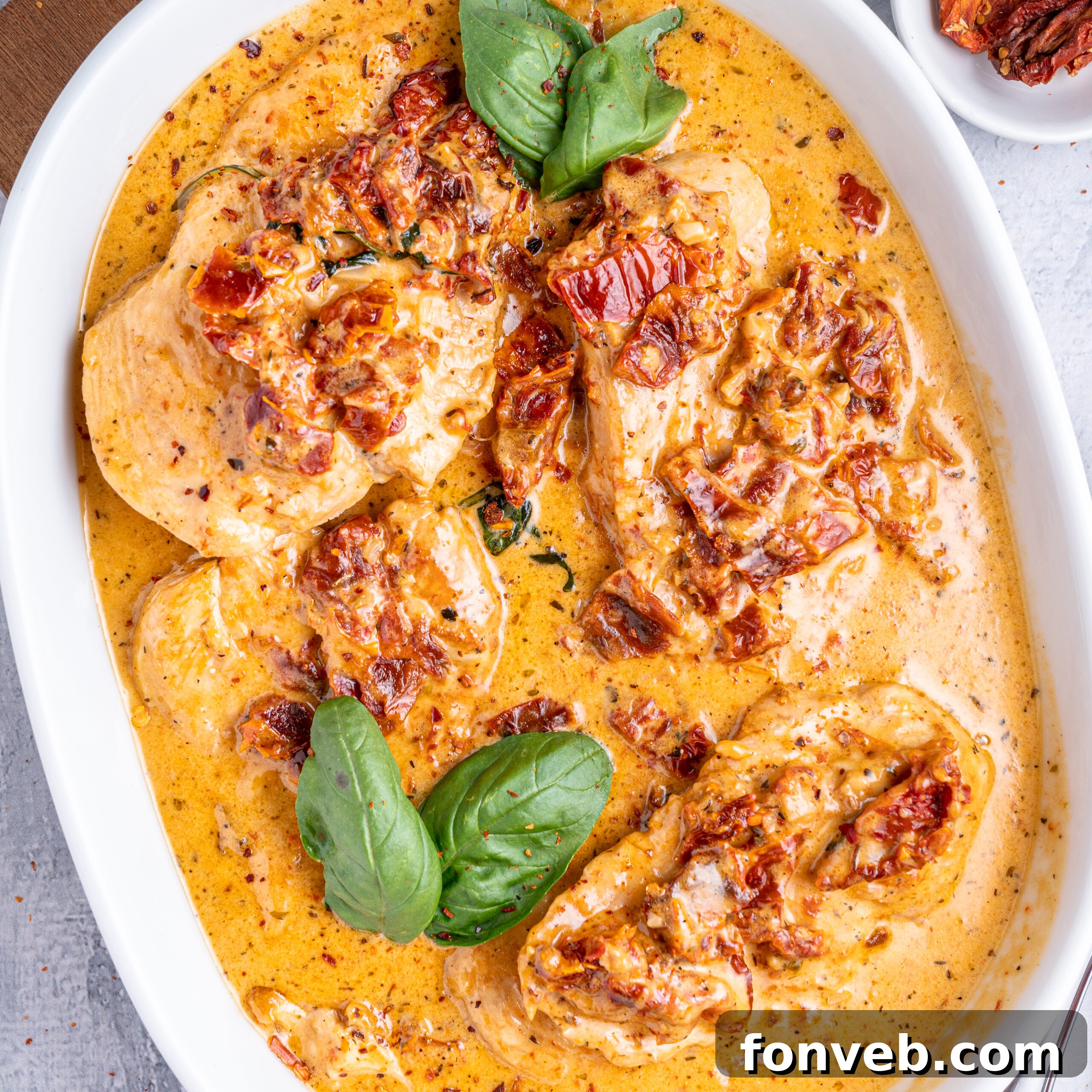 Dreamy Date Night Chicken 3 Marry Me Chicken in a white baking dish topped with fresh basil.