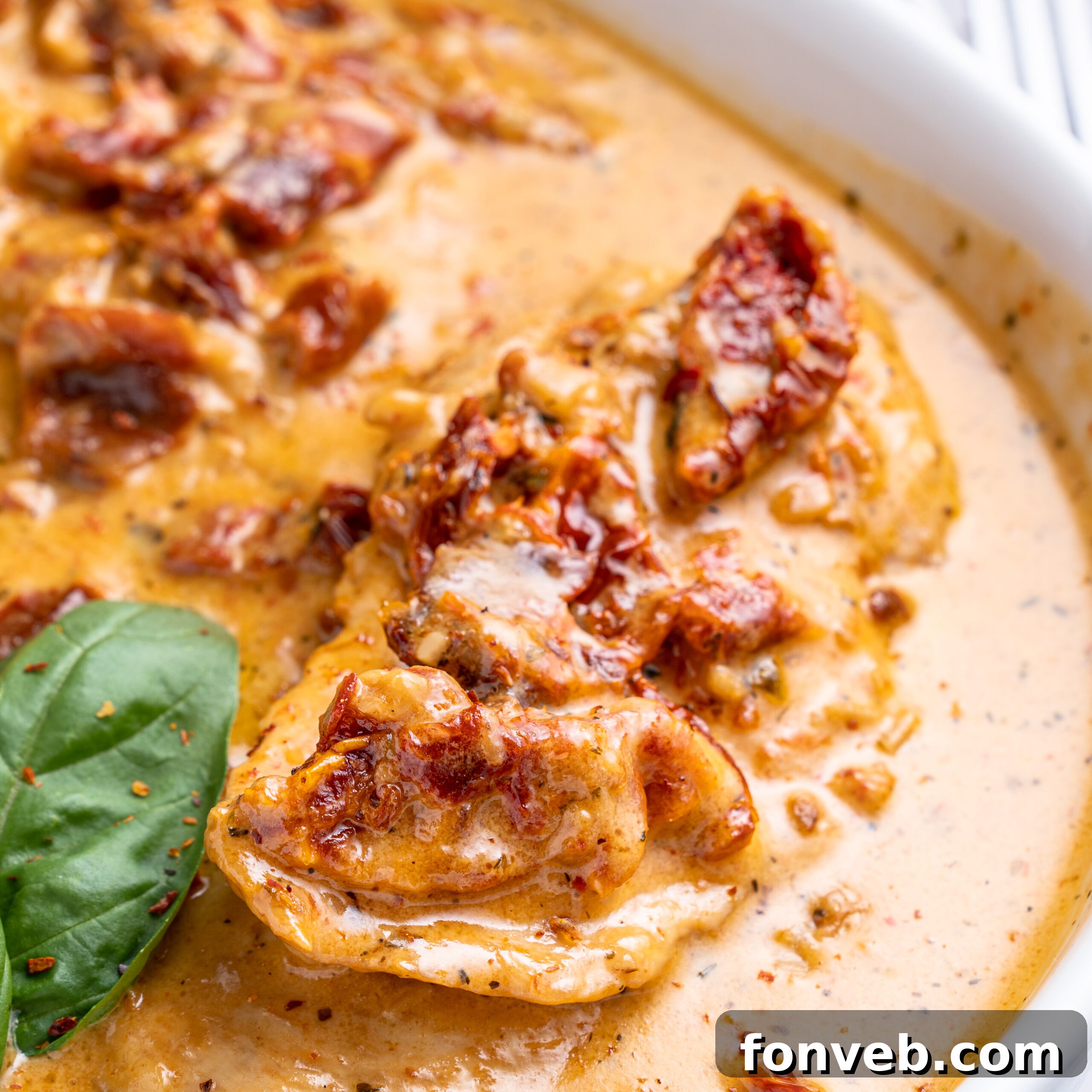 Dreamy Date Night Chicken 4 Close up shot of Marry Me Chicken in a white baking dish topped with fresh basil.