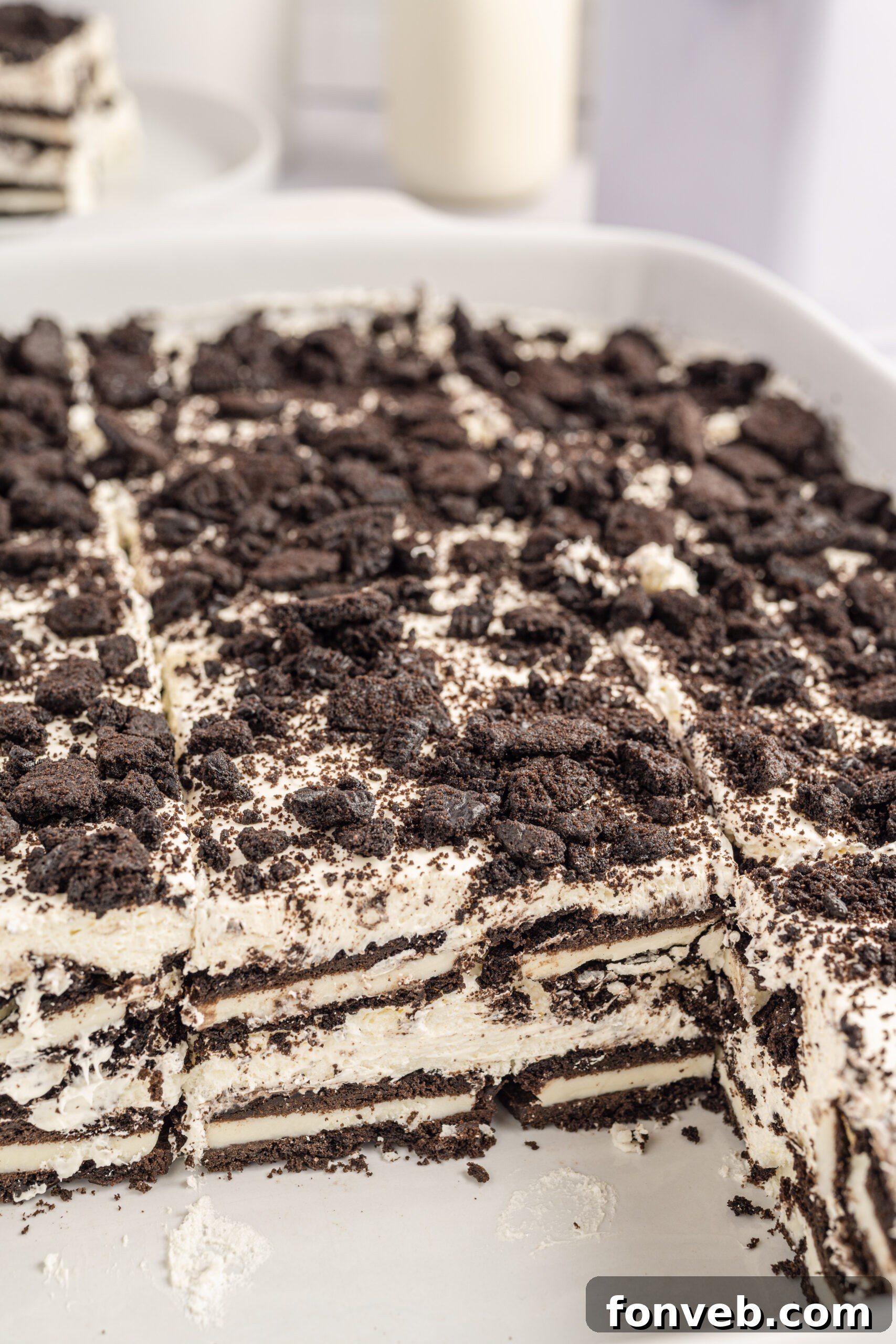 Close up view of Oreo Icebox Cake with two slices removed in a white baking dish.