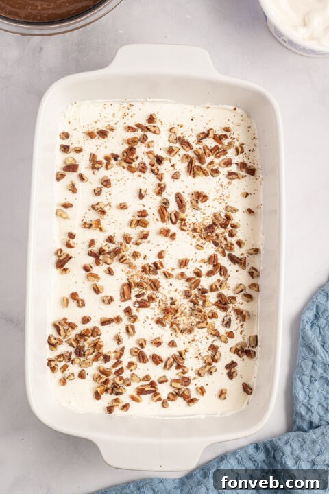 Step-by-step image of spreading the cream cheese mixture over the crust.