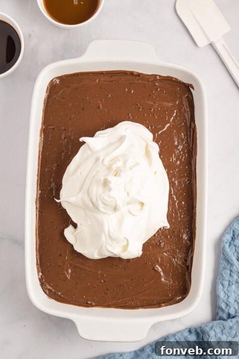 Step-by-step image of sprinkling pecans onto the cream cheese layer.